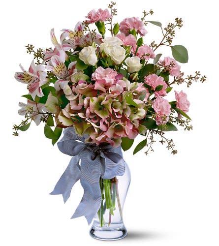 Pink and white mixed bouquet in a clear glass vase with a blue ribbon