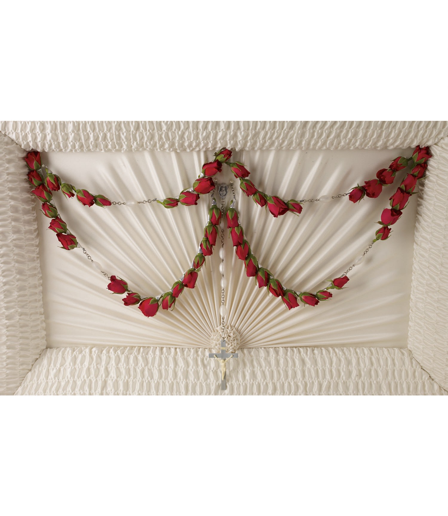 White coffin interior with red rose garlands and a rosary cross