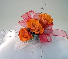 Orange rose corsage with pink ribbon and bead accents