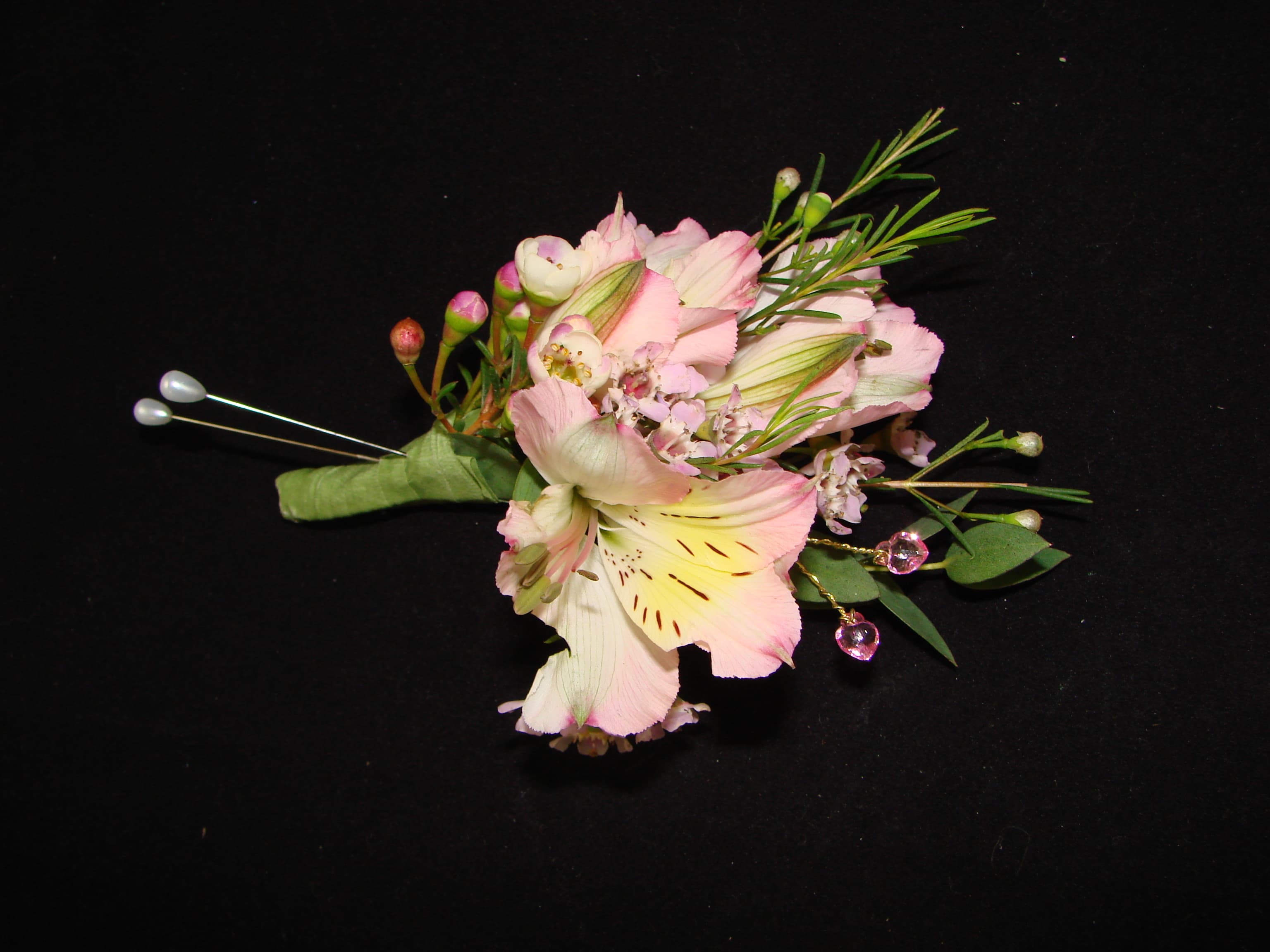 Pink and white floral boutonniere with decorative pins