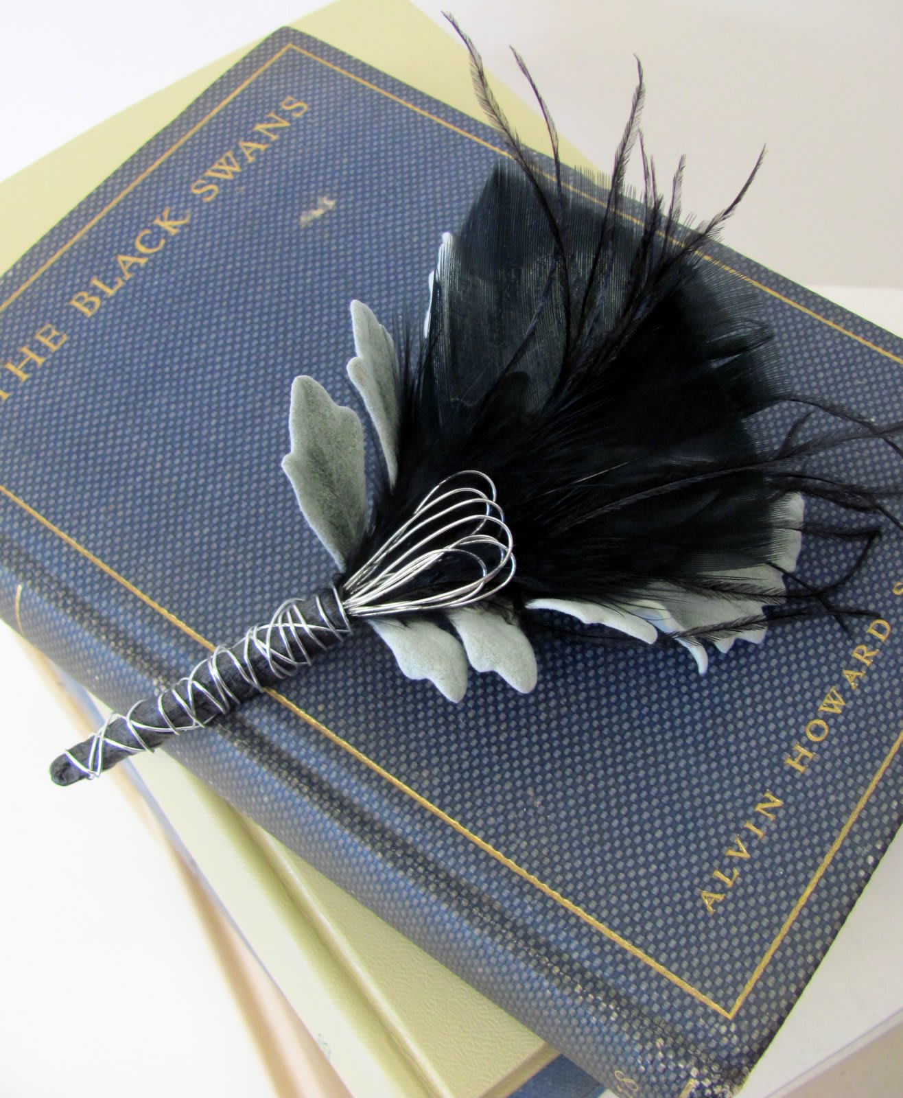 Black feather boutonniere on a boxed item