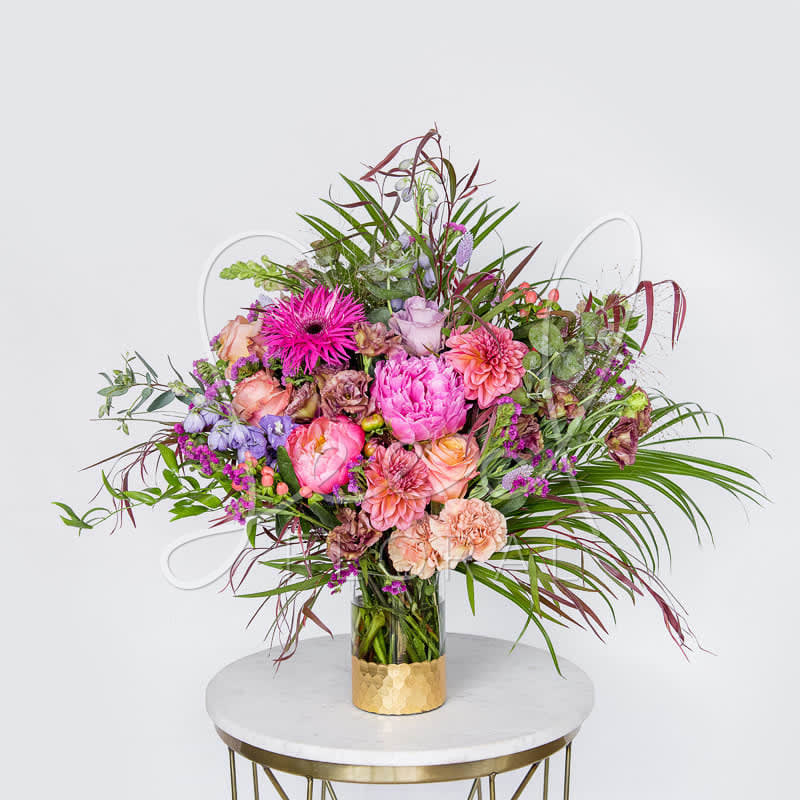 Large mixed bouquet in a glass vase with pink and peach flowers