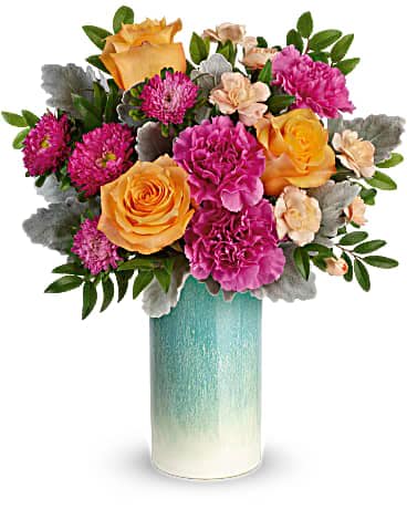 Teleflora's Aqua Allure Bouquet - Just peachy! Celebrate spring or any season, with this lush orange and pink bouquet, artfully gathered in a sunset-inspired peach glass vase with shimmering pearlized finish. This bouquet features peach roses, dark pink carnations, peach miniature carnations, hot pink matsumoto asters, dusty miller, and huckleberry. Delivered in an Aqua Allure cylinder.