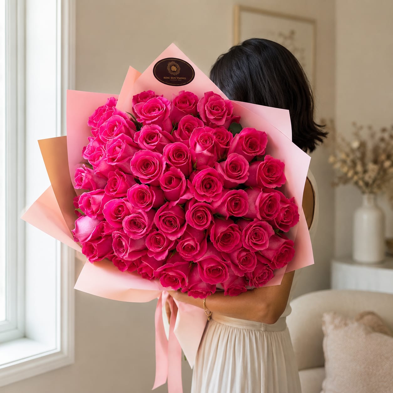 Large bouquet of bright pink roses wrapped in pale pink paper