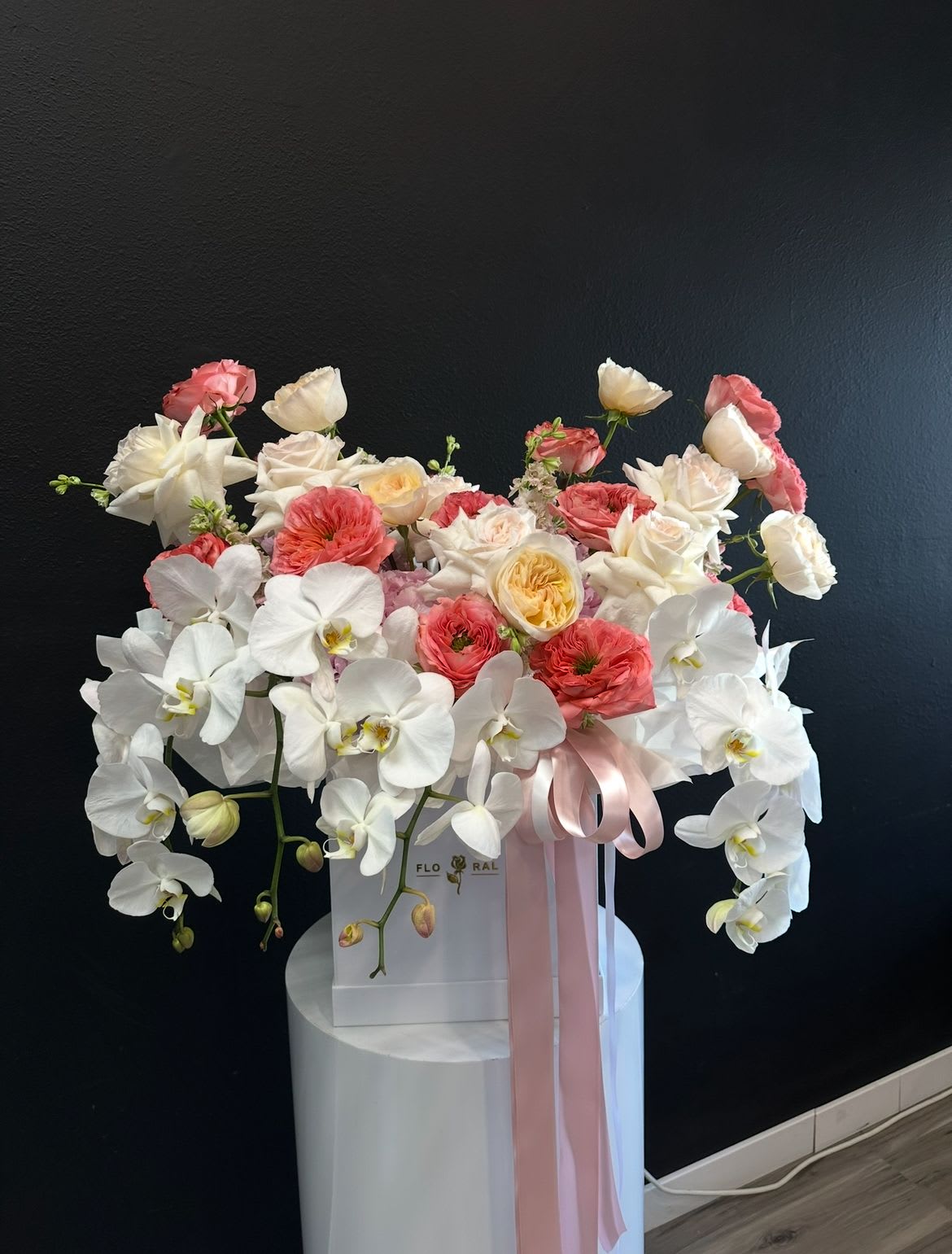Large white orchid and pink rose arrangement in a white box with pink ribbon
