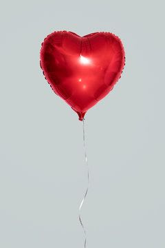 Red heart-shaped balloon with a thin string