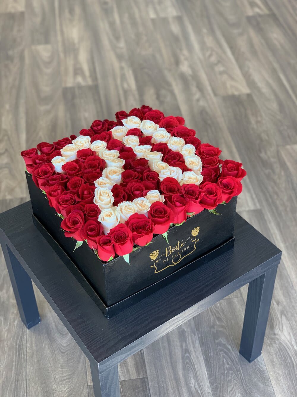 Square box of red and white roses arranged in a heart pattern