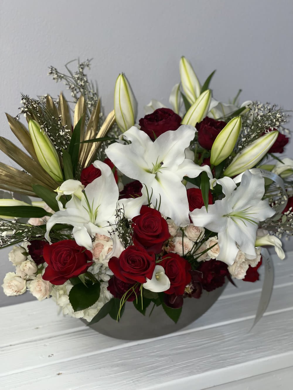 Red roses and white lilies in a gray vase