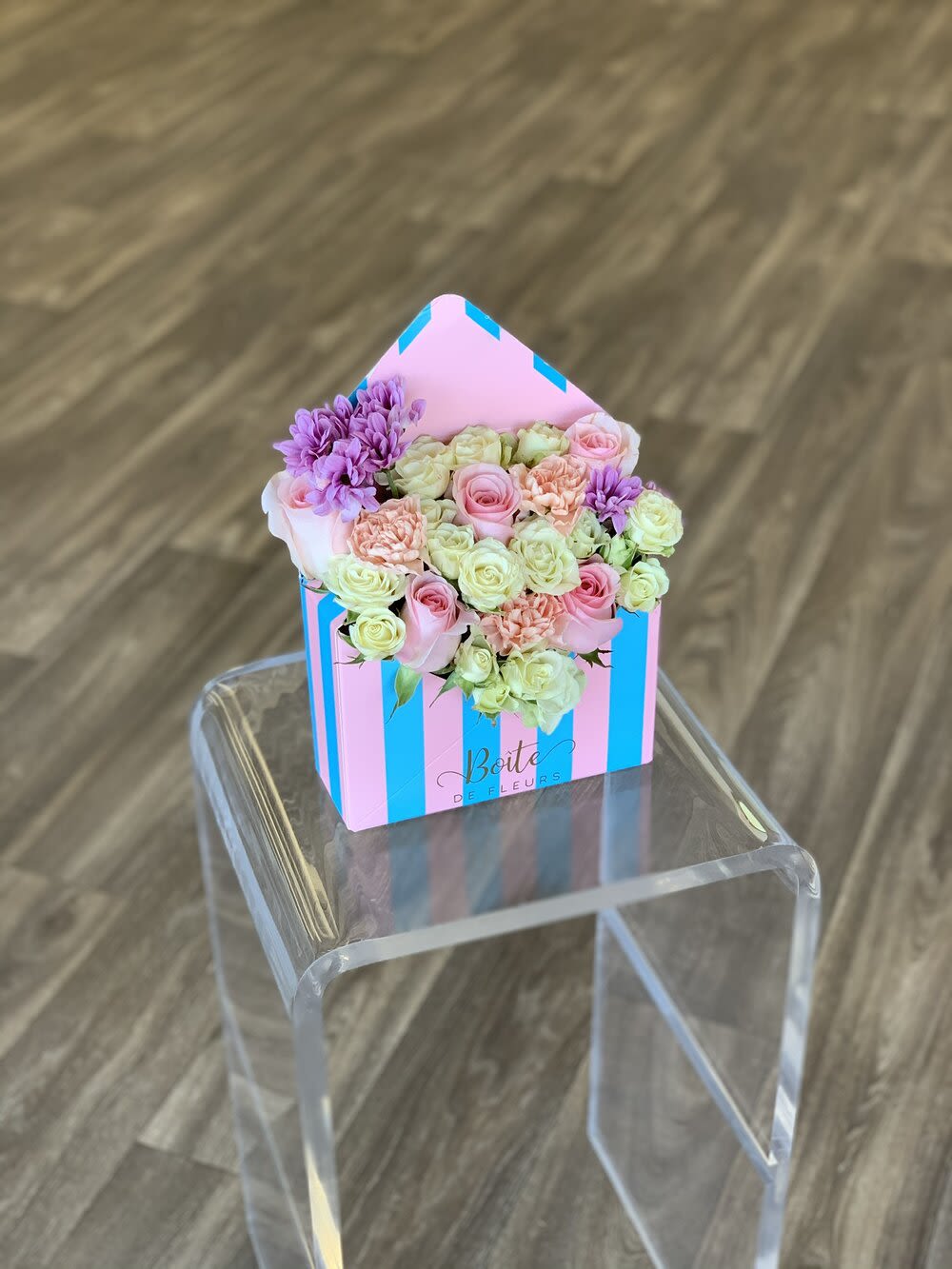 Pastel roses and chrysanthemums in a striped house-shaped box