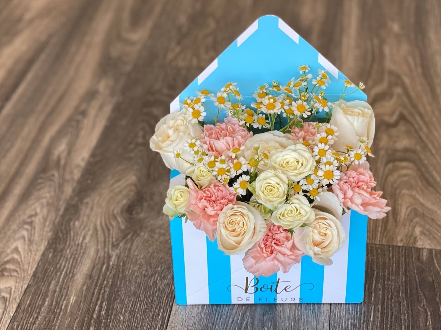Box of cream roses, pink carnations, and small daisies