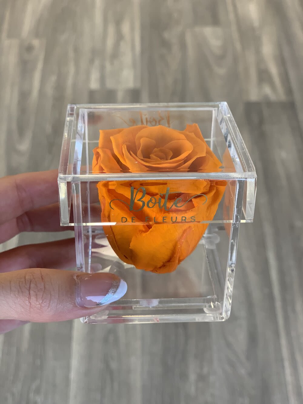 Single orange rose in a clear acrylic box