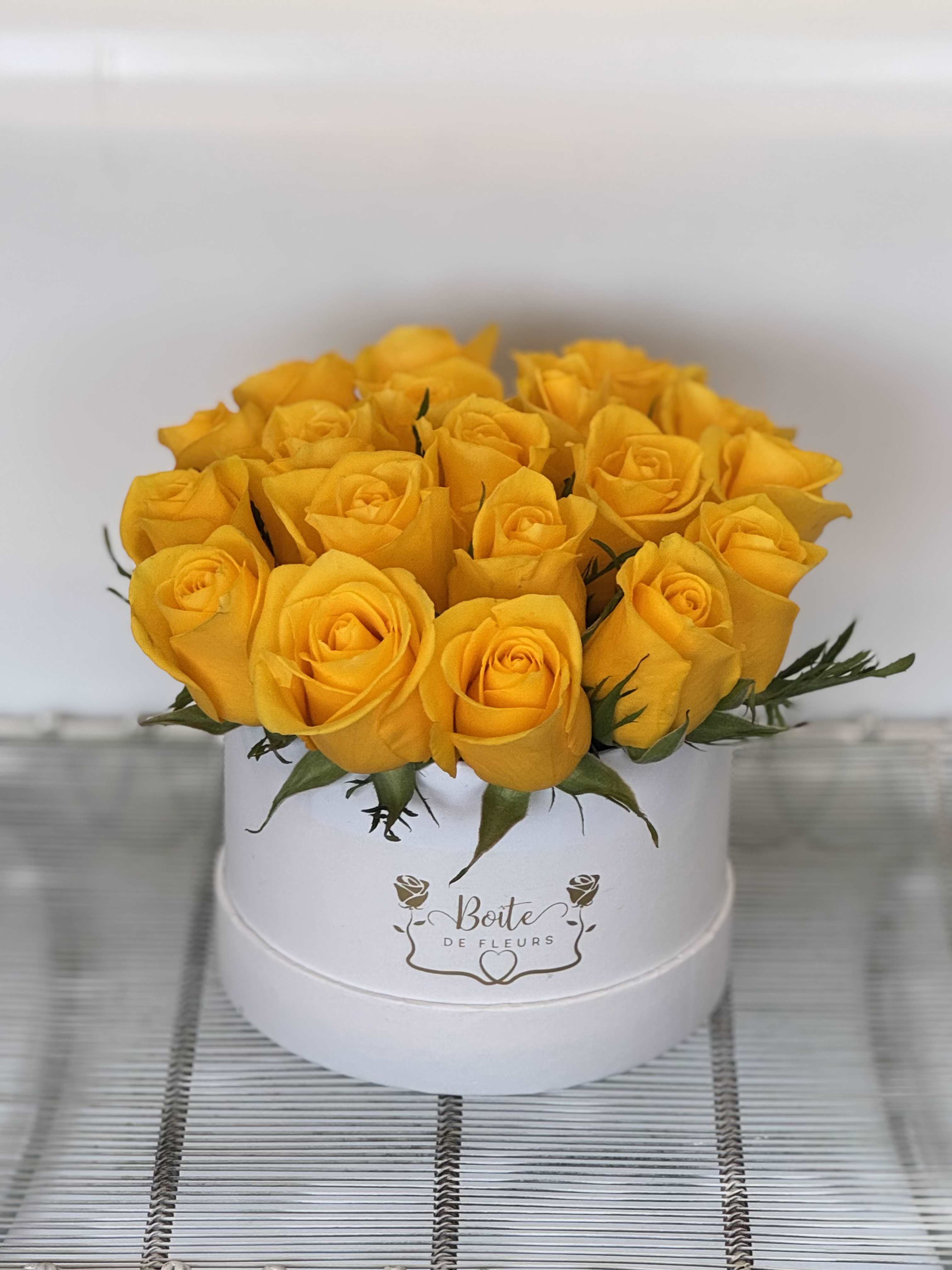 Yellow roses arranged in a white round box