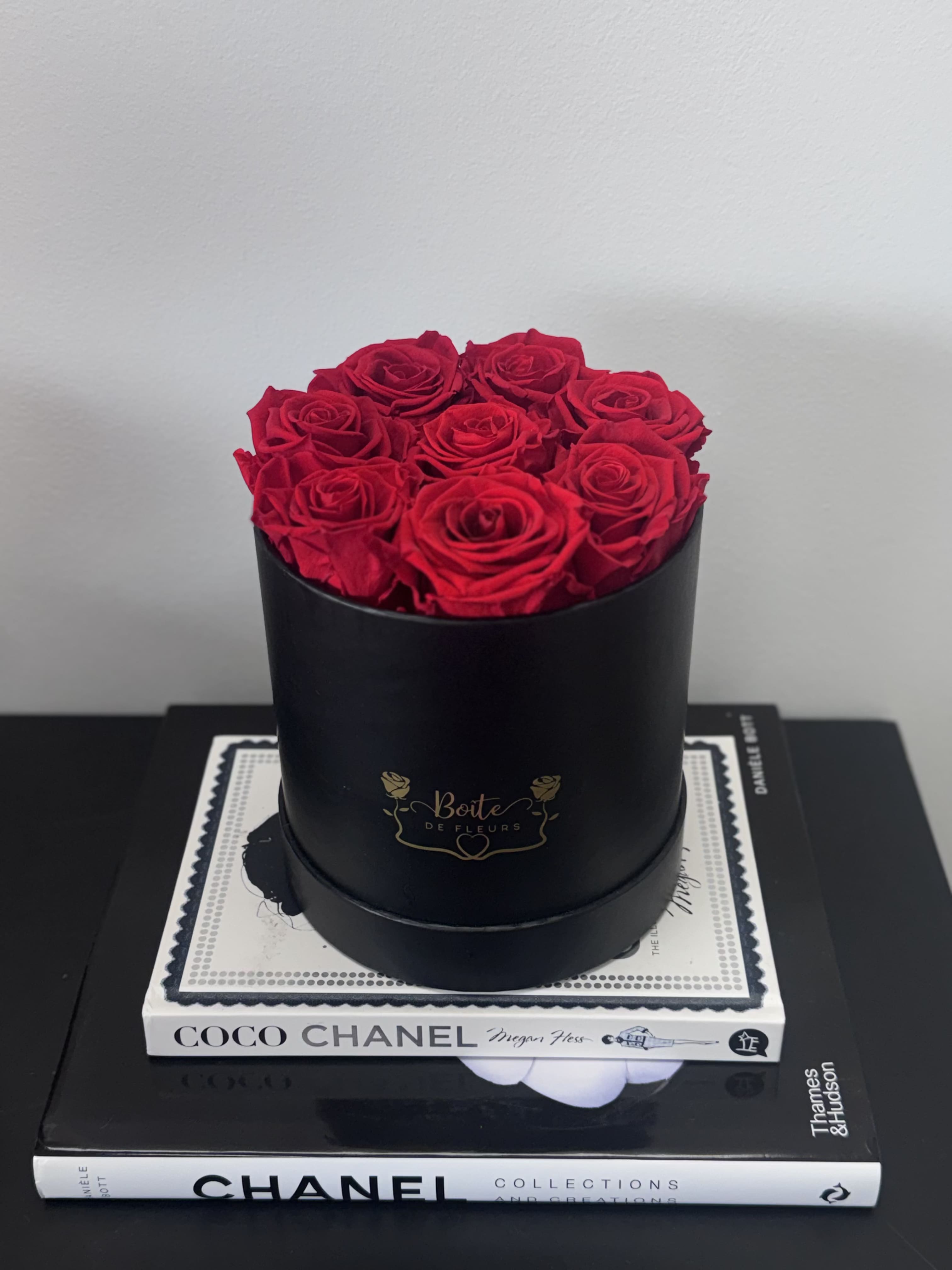 Red roses arranged in a black round box