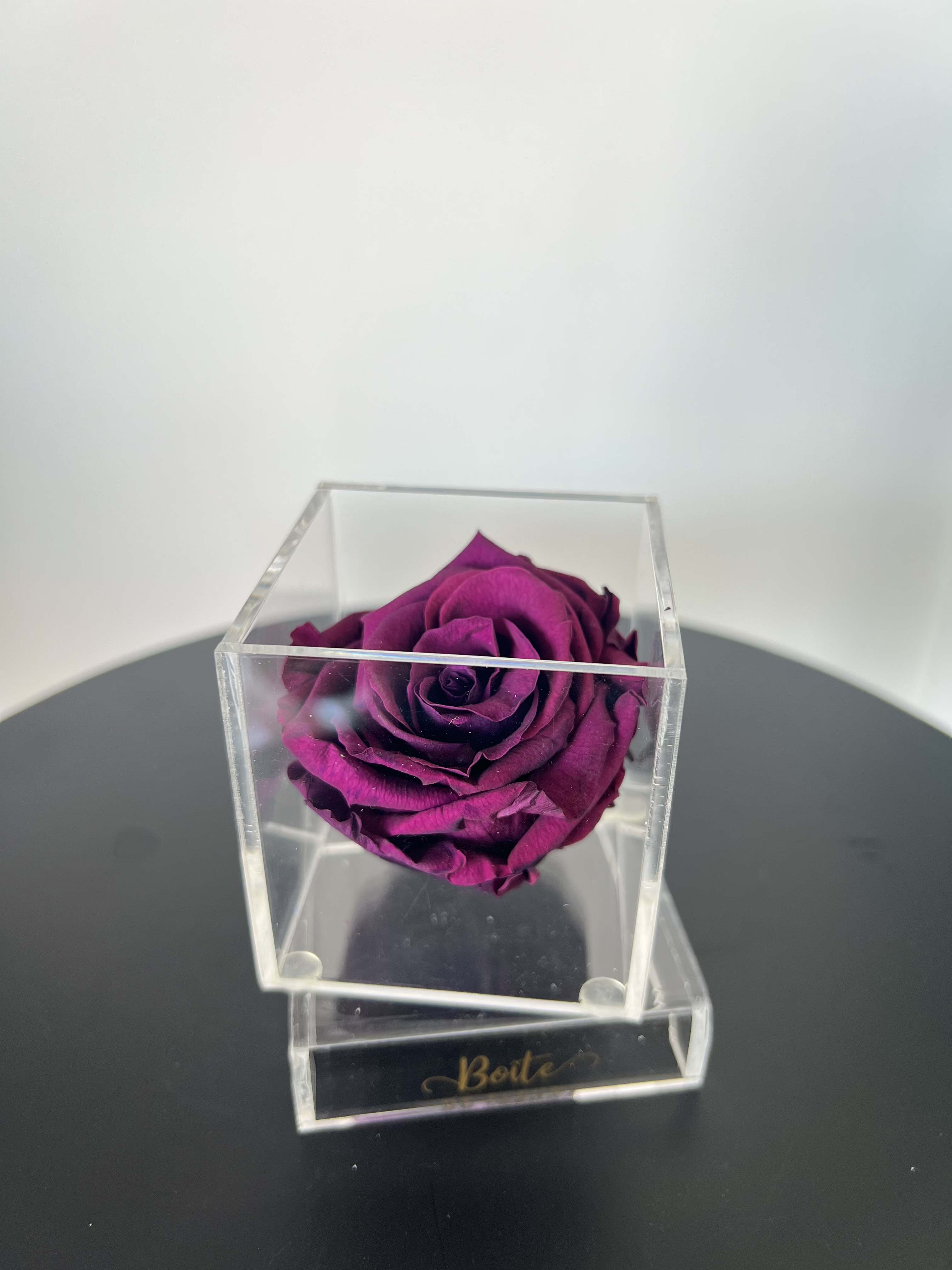 Petit Forever Boîte (Dark Magenta) - A single forever rose sits in a custom acrylic box. This petit boîte is the perfect addition to your make up vanity, kitchen, bathroom counter, nightstand, or anywhere that needs a small beautiful rose decoration! Forever roses can last 3+ years with the proper love and care. 
