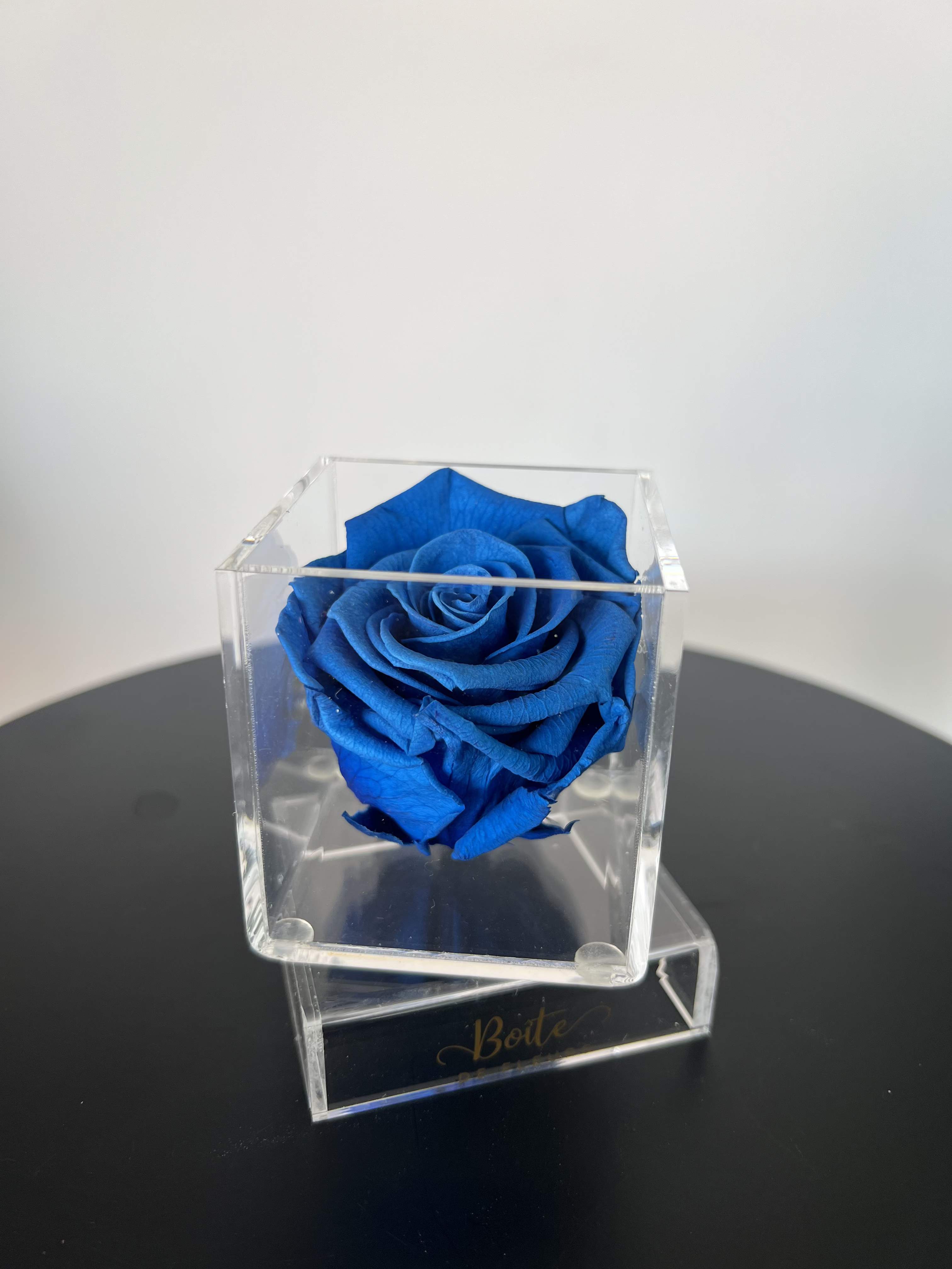Petit Boîte (Dark Blue)  - A single forever rose sits in a custom acrylic box. This petit boîte is the perfect addition to your make up vanity, kitchen, bathroom counter, nightstand, or anywhere that needs a small beautiful rose decoration! Forever roses can last 3+ years with the proper love and care.