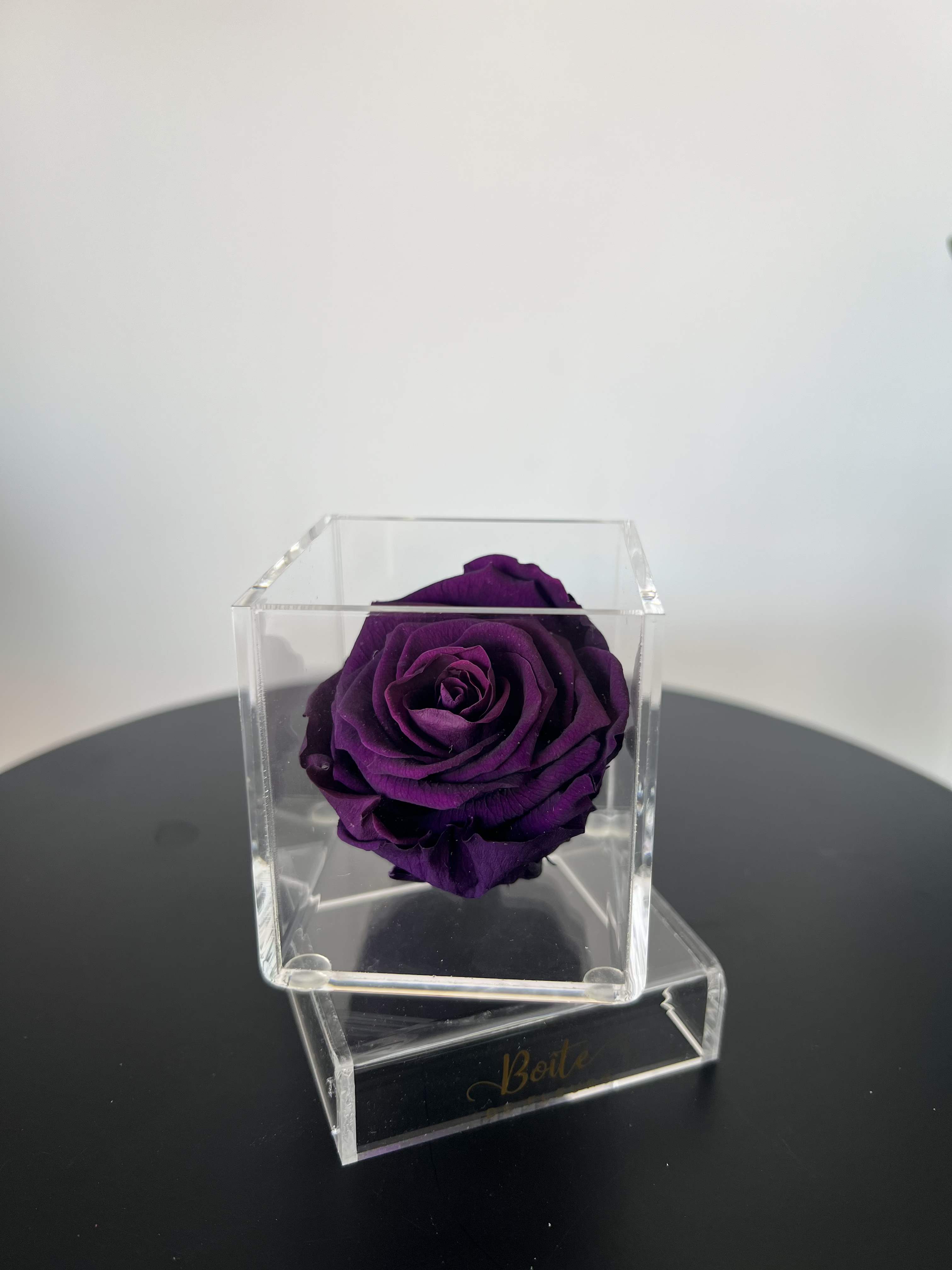 Petit Forever Boîte (Dark Purple) - A single forever rose sits in a custom acrylic box. This petit boîte is the perfect addition to your make up vanity, kitchen, bathroom counter, nightstand, or anywhere that needs a small beautiful rose decoration! Forever roses can last 3+ years with the proper love and care.