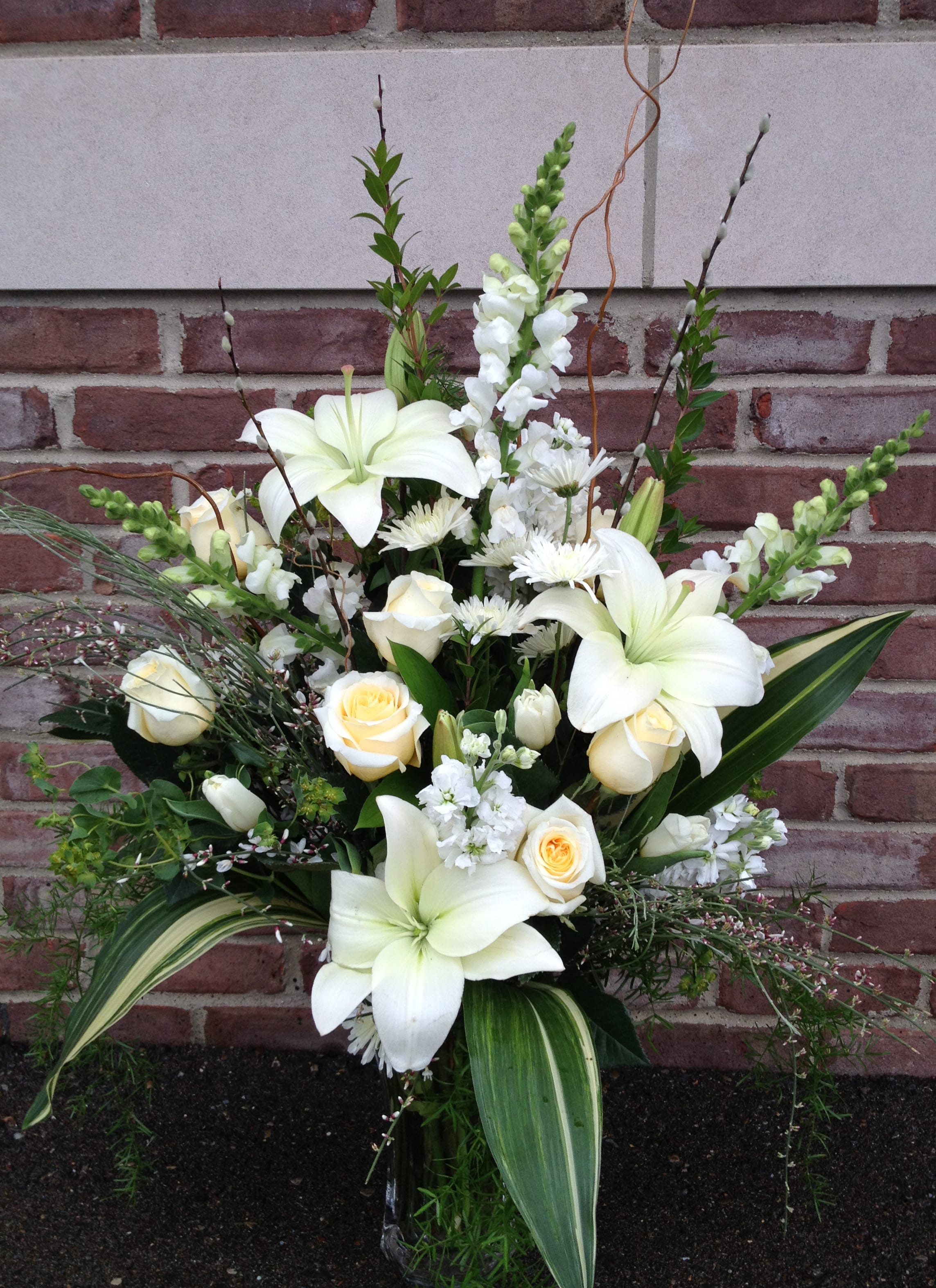 White lilies and cream roses in a tall arrangement
