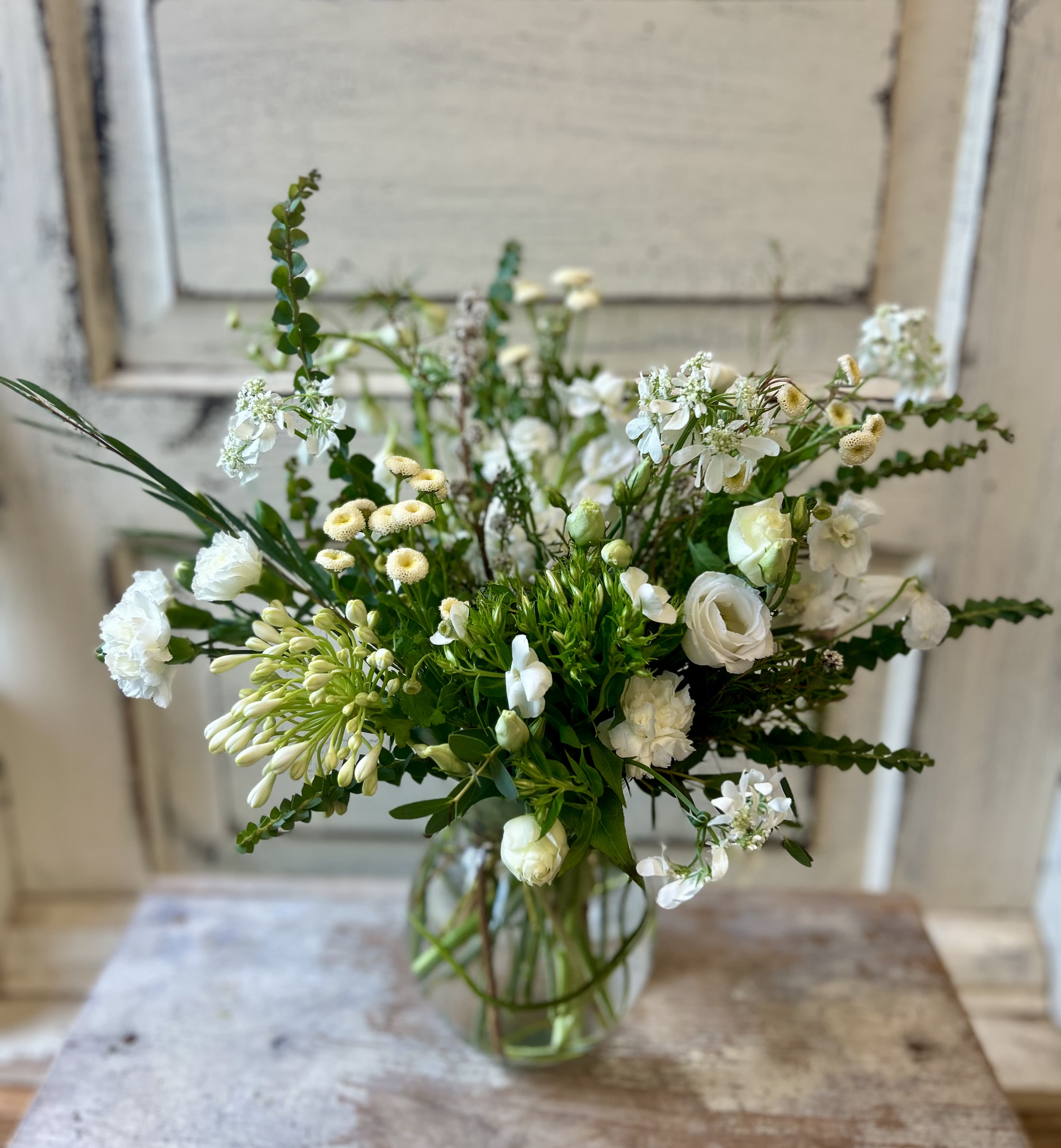 All White Mini Vase - A petite and sweet way to show that you care, this vase contains a unique assortment of white blooms and foliage. Flower varieties will vary week to week and season to season but the effect is always beautiful.