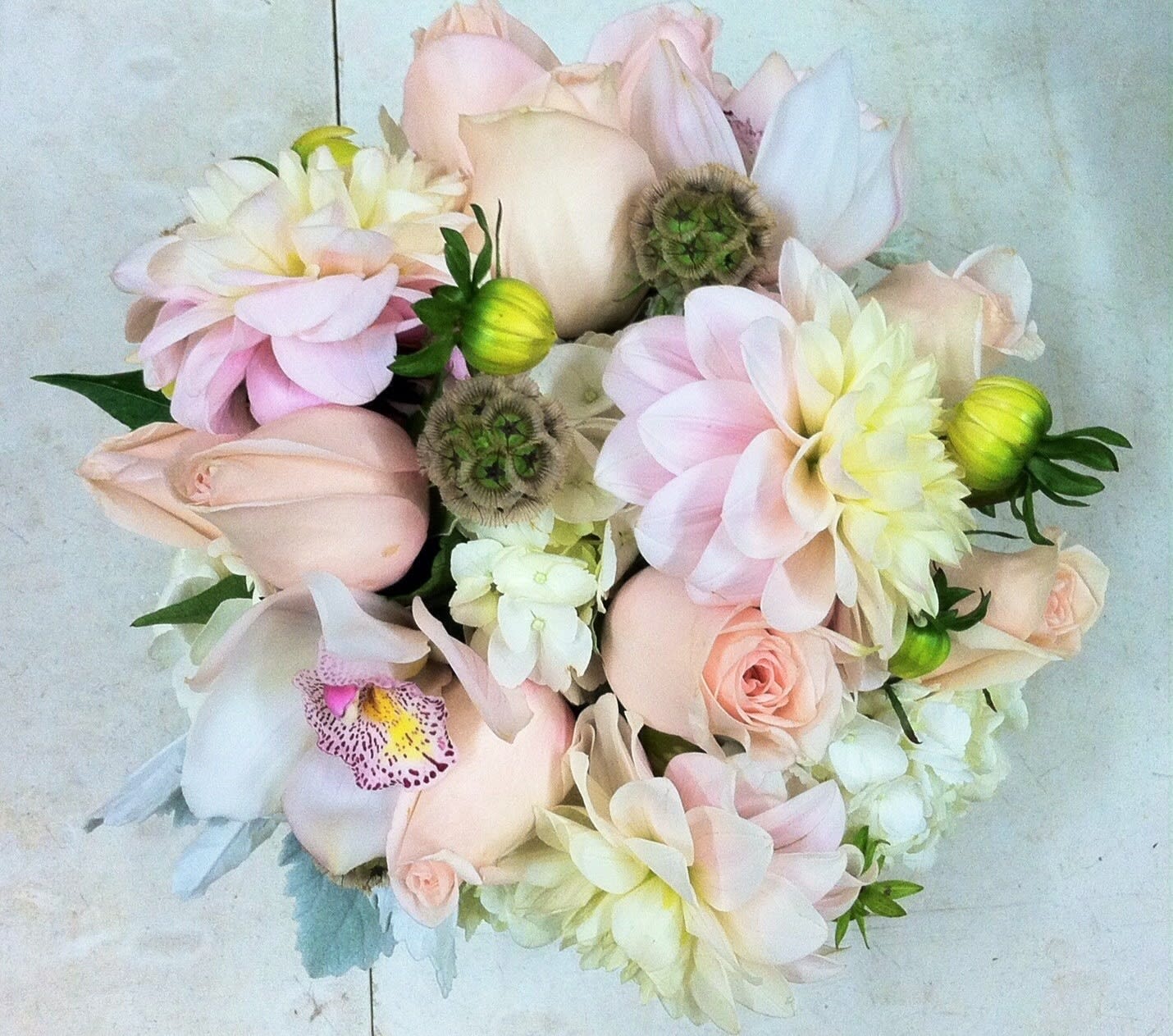 Soft pink and white bouquet with roses, orchids, and dahlias