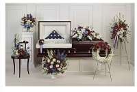 Multiple patriotic floral funeral arrangements with red, white, and blue flowers