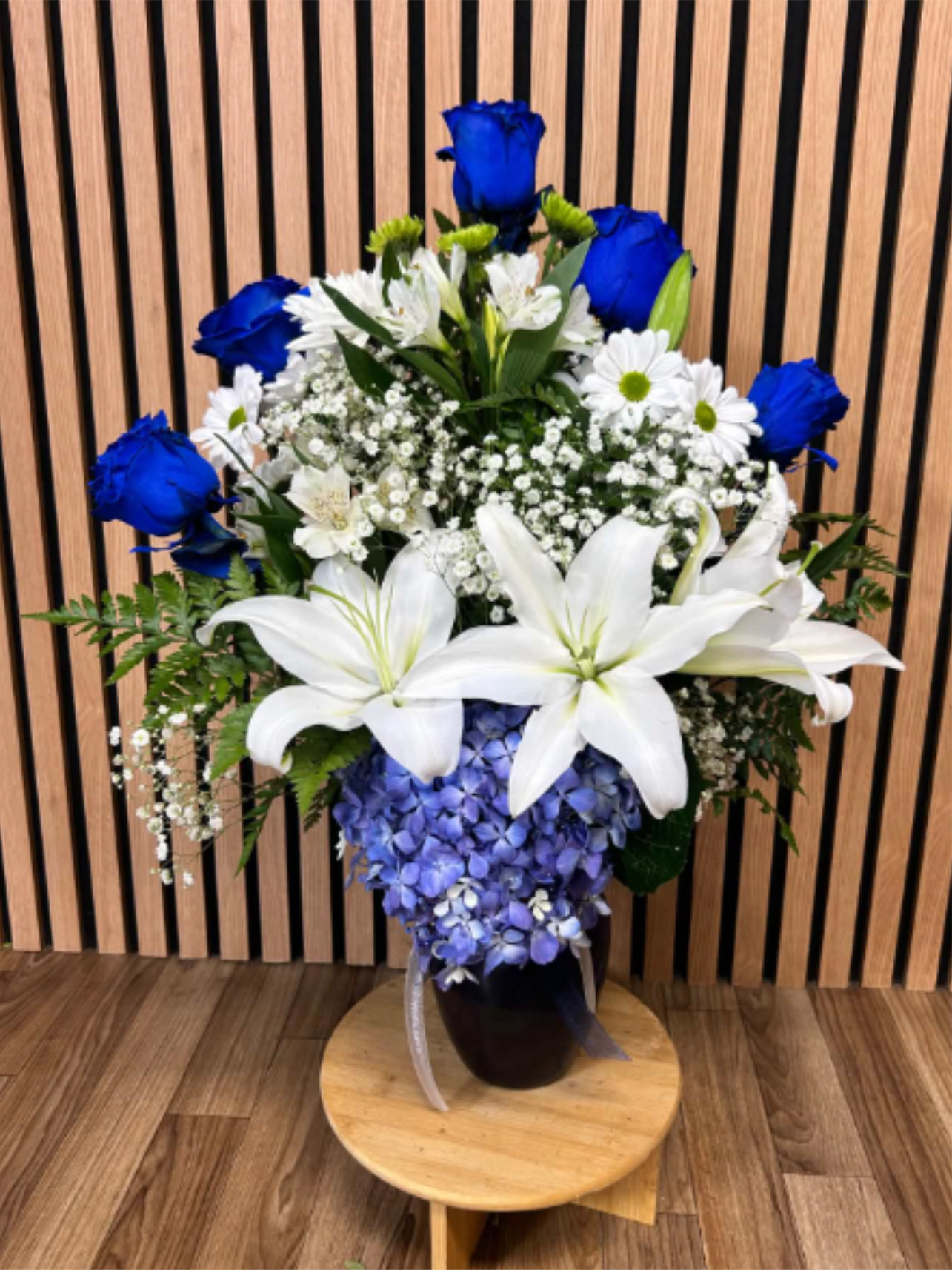 Blue MaJesty - Vivid cobalt-blue roses and large white lilies create an arresting contrast in this flower arrangement-Blue MaJesty is a cool, elegant bouquet perfect as a birthday bouquet, anniversary arrangement, or thoughtful thank-you gift. The dramatic mix of blue, white, purple, and green reads refined and modern, the kind of floral gift that makes the person you're thinking of feel truly seen and celebrated.  