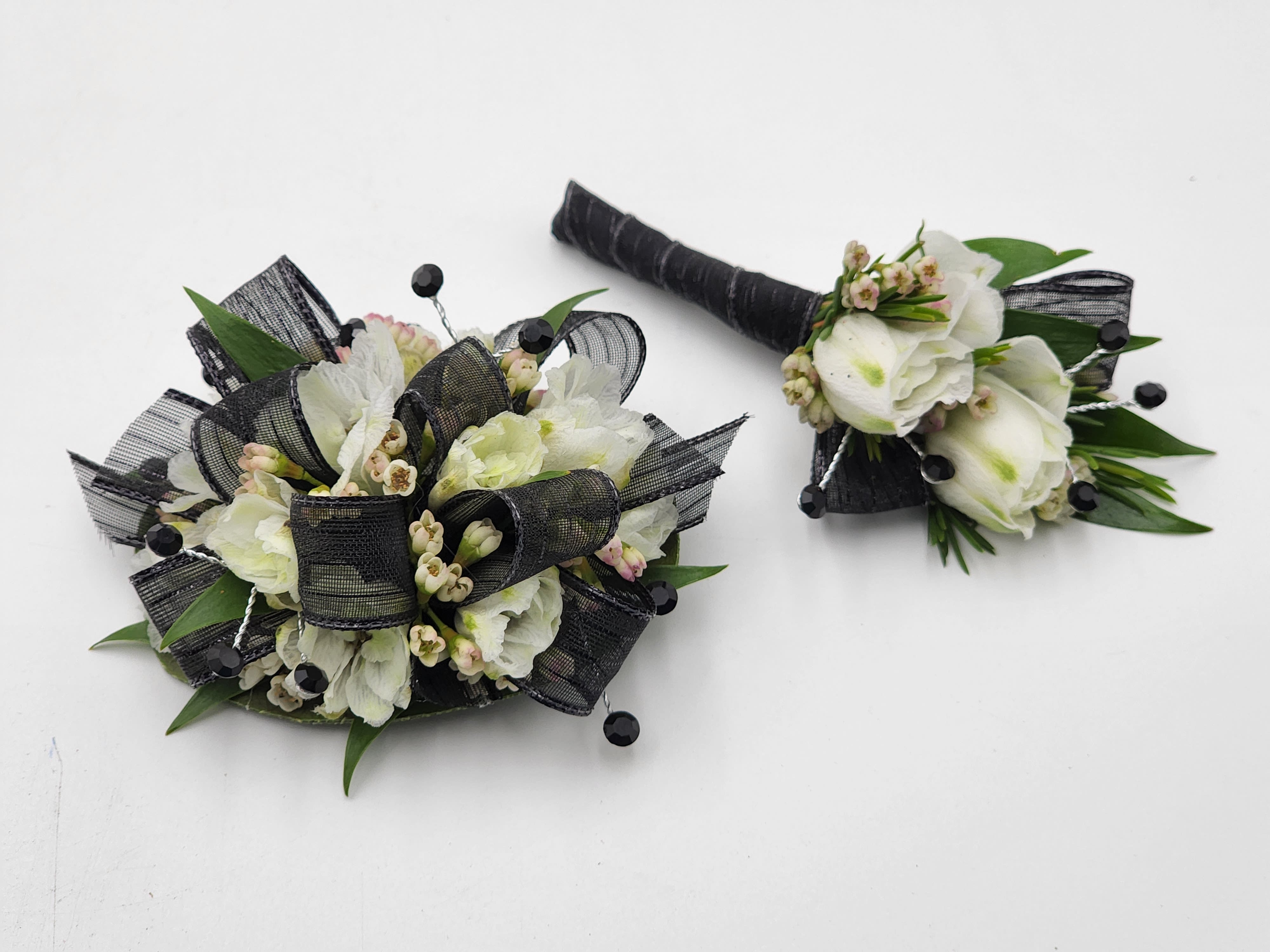 Masquerade Mystery Boutonniere And Wristlet Set - A boutonniere and wrist corsage featuring white larkspur, black ribbon &amp; black rhinestones.   Depending on availability of ribbon, may change slightly.