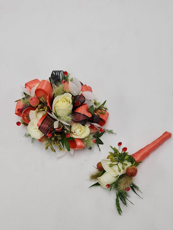 Coral Romance Boutonniere and Wristlet Set - Select this coral themed boutonniere and corsage set featuring spray roses, bunny tail, bleached ruscus and peach hypericum with accents of red rhinestones, coral and black ribbon. The wristlet corsage will come on a standard grey wristband that is elastic. The boutonniere will come with two black pins to pin on their lapel or shirt.