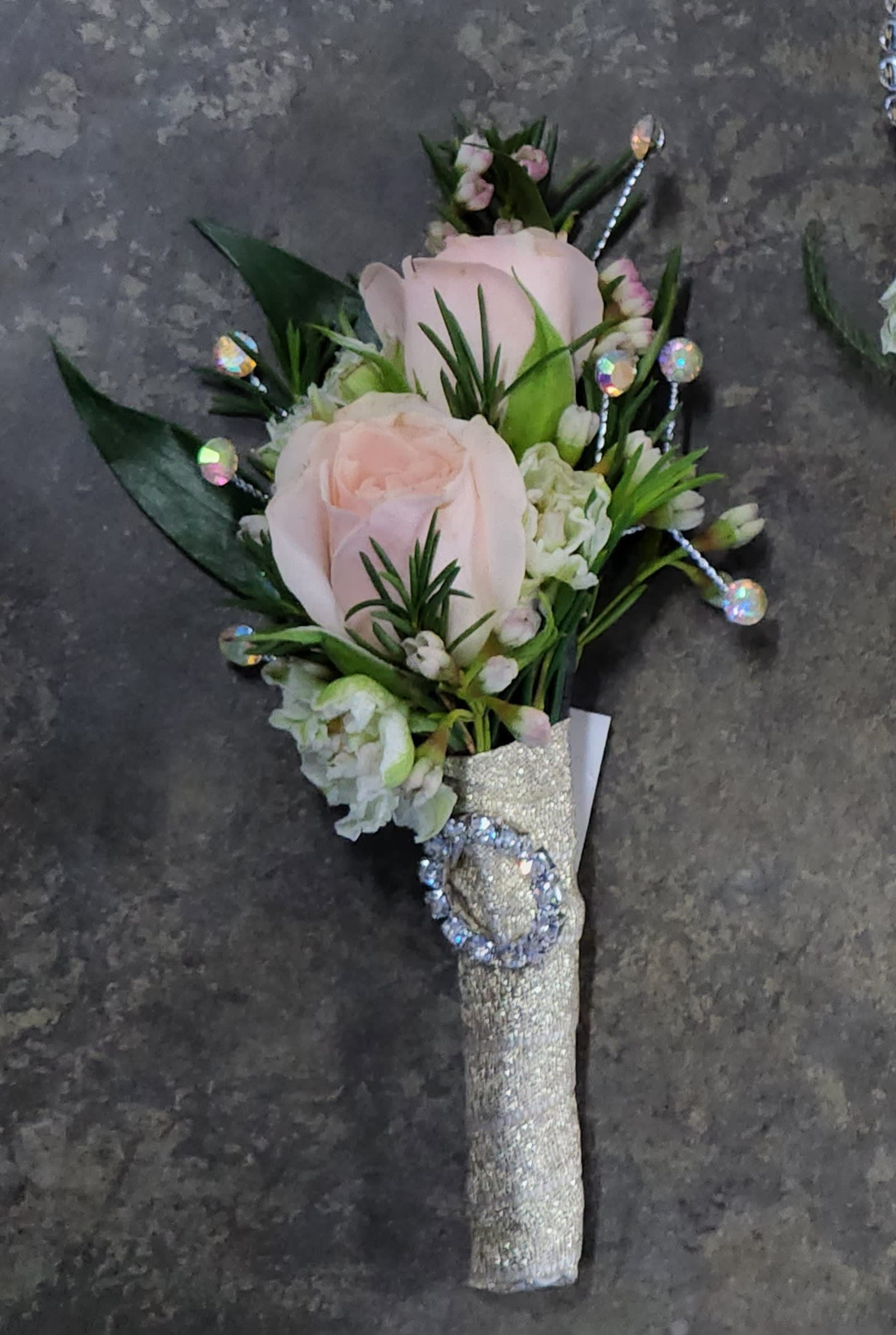 Festival of Lights Boutonniere - A boutonniere with light pink spray roses, white larkspur blooms, rhinestones.  If you would like to add lights to the boutonniere as shown in the Festival of Lights Wristlet Corsage please call our store at 530-758-5050.