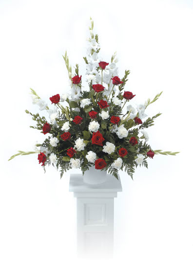 Loving Tribute Pedestal Arrangement - Your thoughtful wishes are captured perfectly with our Loving Tribute Pedestal Arrangement that includes premium red roses, carnations, and gladiolus.  While we always try to follow the color palette, we may sometimes need to replace certain flowers to deliver the freshest, and in some cases, the fastest bouquet possible. Any substitutions will be of equal or greater value to the original flowers or container.  Approximately 36" tall x 40" wide