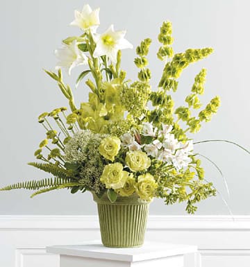 Simply Serene Sympathy Arragngement - The Simply Serene Sympathy Arrangement is a perfect mix of lush florals in a stylish monochronmatic design of roses, hydrangeas, lilies, and Bells of Ireland. Whether the services are held in a funeral home or church, this arrangement will blend in beautifully with any other array of flowers in a memorial setting.  Product Information Our Square Foliage Standing Spray is a unique modern piece for a truly one-of-a-kind memorial tribute!  Approximately 32"h x 34" w   Depending on seasonal availabilty, substitutions may be made. Colors, style, and value will remain close to the general style and theme of the original arrangement   For Delivery to the following Funeral Homes, Mortuaries, and Crematories in East Moline and other Quad Cities: Van Hoe Funeral Home, Esterdahl Mortuary &amp; Crematory, Sullivan Ellis Mortuary, Schroder Mortuary, Wheelan Pressly Funeral Home, Rafferty Funeral Home, Trimble Funeral Home, DeRoo Funeral Home, Orr Mortuary, Knox Chapel, Wendt Funeral Home, McGinnis Chambers Funeral Home, Cunnick Collins Funeral Home, Runge Mortuary, Weert Funeral Home.  
