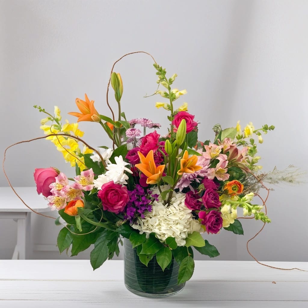 Colorful Embrace Bouquet - The Colorful Embrace Arrangement is a striking, high-design floral composition created for those who appreciate bold color and refined artistry. Featuring a curated mix of premium blooms in rich, expressive tones, this arrangement is thoughtfully styled to feel abundant, modern, and effortlessly elevated.    Designed to make an impression, Colorful Embrace brings beauty and energy to interiors, celebrations, and meaningful moments — from client gifting and special occasions to indulgent everyday luxury. This Hignight Florist exclusive is artful, confident, and unmistakably chic.    Available for delivery throughout the Quad Cities in Illinois and Iowa, including East Moline, Moline, Silvis, Hampton, Colona, Carbon Cliff, Coal Valley, Rock Island, Bettendorf, and Davenport.  