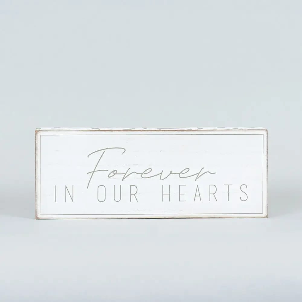 Forever in Our Hearts Remembrance Sign - Introducing our heartfelt "Forever in Our Hearts" wood brick, a thoughtful addition to any sympathy or remembrance setting. Measuring 10.25 x 4 x 1.5 inches, this elegant piece is crafted in a soothing white and grey palette, making it a versatile accent for tabletops or trays. The gentle sentiment serves as a comforting reminder of enduring love and cherished memories, offering solace and peace during difficult times. Perfect for honoring a loved one's memory, this decorative piece is both meaningful and tasteful.  Note: Standard size includes sign only. Deluxe and Premium sizes include the sign in a floral arrangement with colors and blooms appropriate for the season.   Note: Standard size includes sign only. Deluxe and Premium sizes include the sign in a floral arrangement with colors and blooms appropriate for the season.