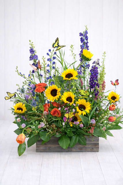Mixed bouquet with sunflowers, orange roses, and purple blooms in a wooden box