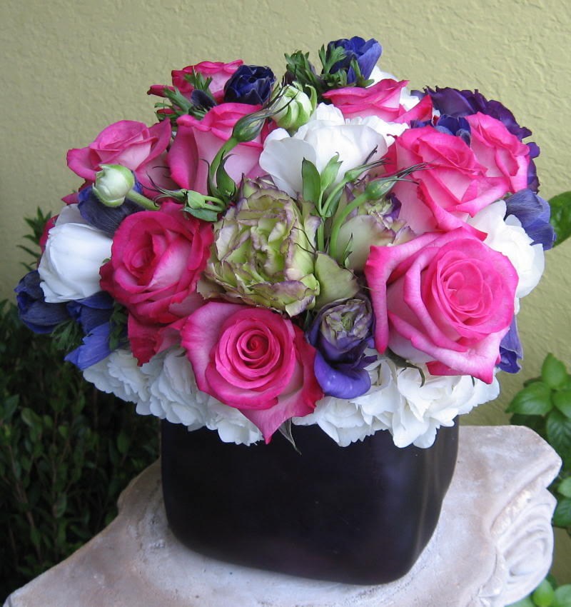 Bouquet of pink, white, and purple roses in a black vase