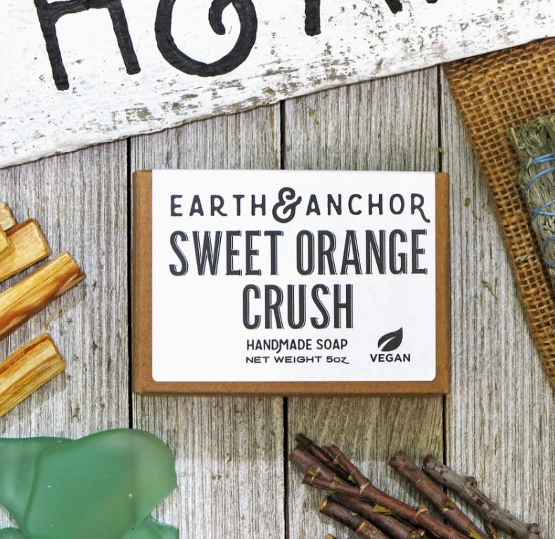 Boxed handmade soap labeled Sweet Orange Crush on a rustic wood surface