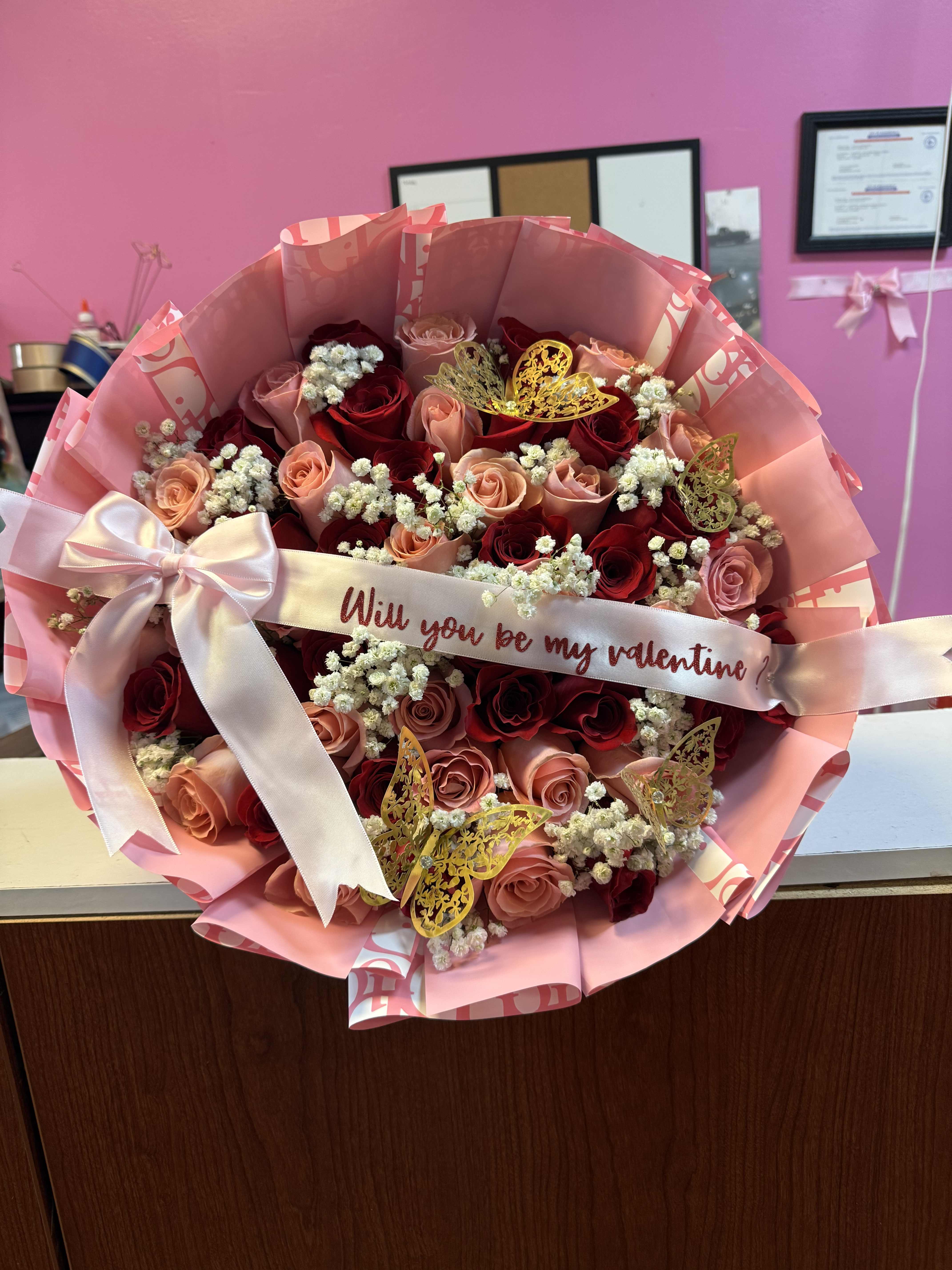 Bouquet of red and blush roses with a pink ribbon and Valentine message