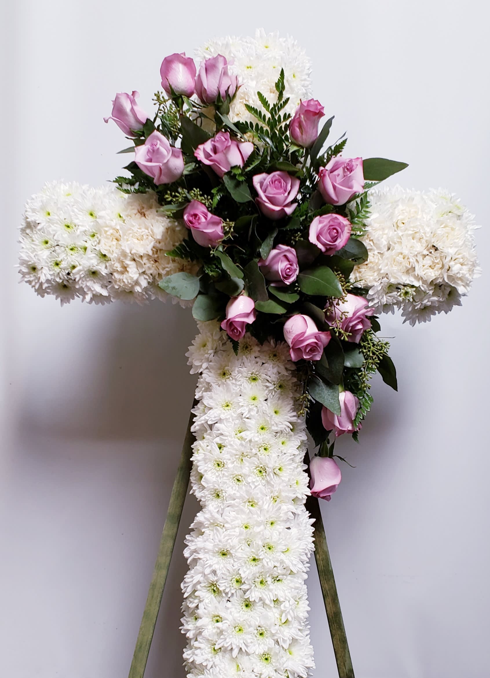 Cross-shaped floral tribute with pink roses and white chrysanthemums