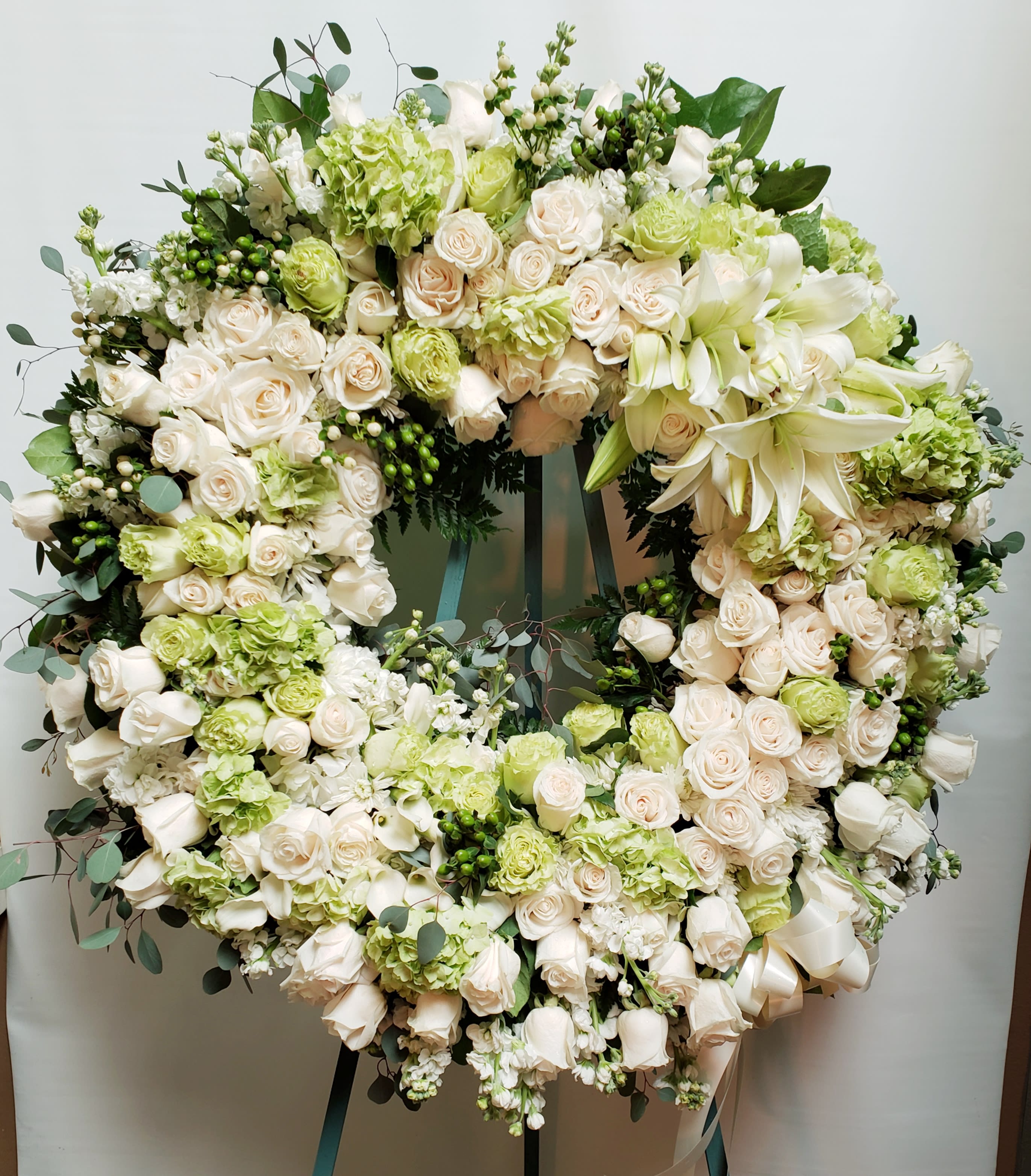 Large circular wreath of white and pale green flowers on an easel