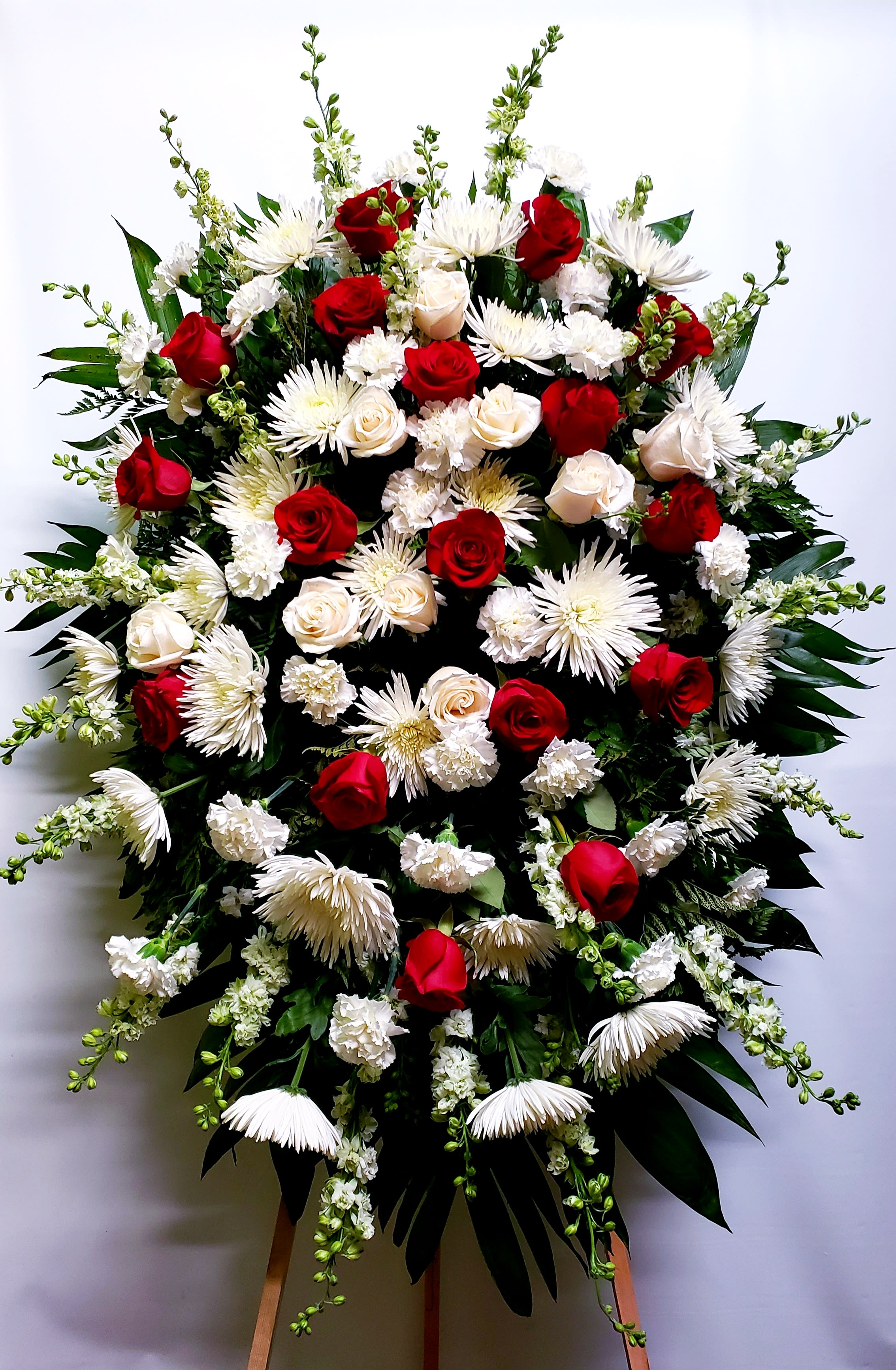 Large standing spray of red and white flowers on an easel