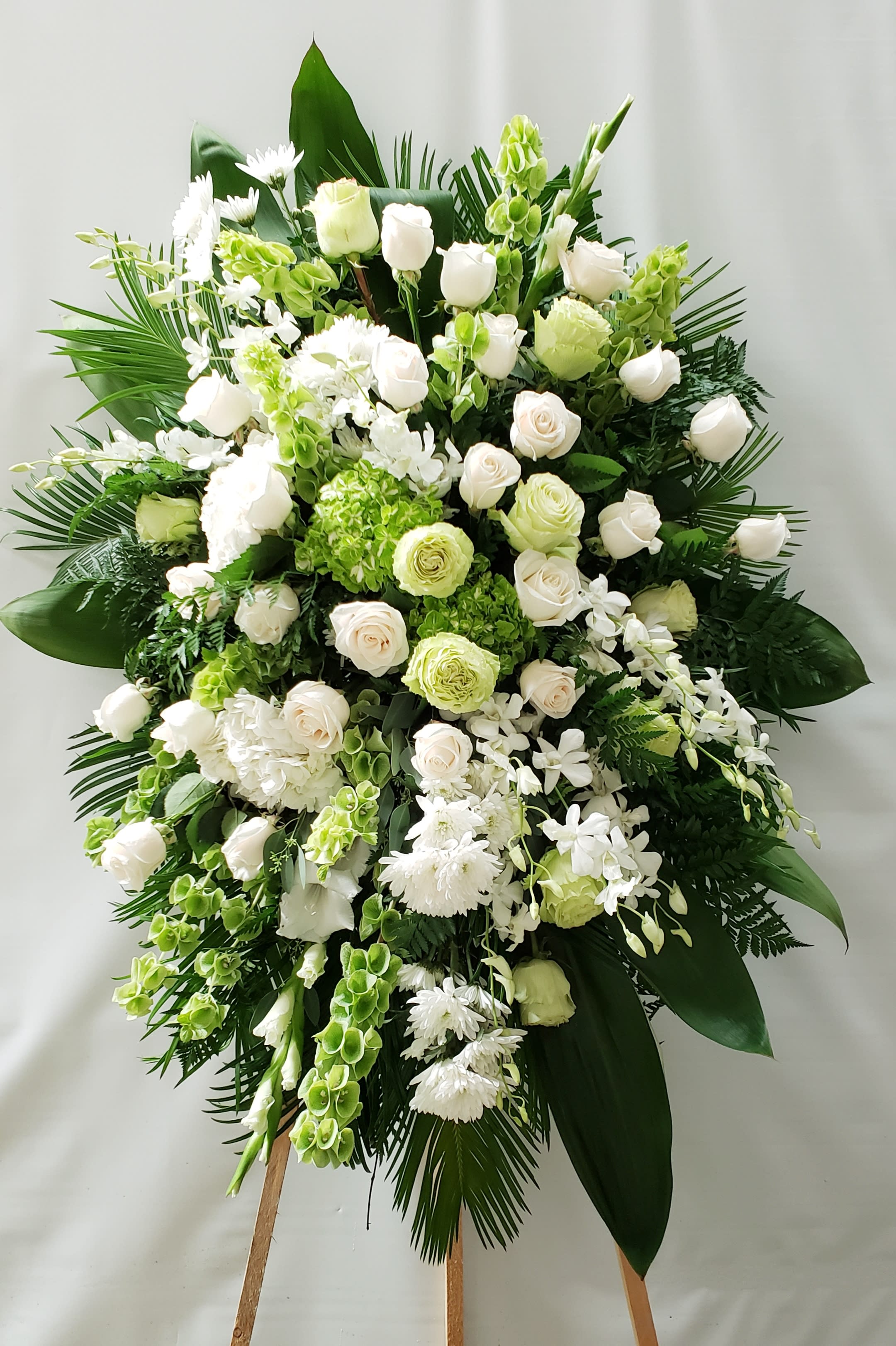 Large white and green floral standing spray on an easel