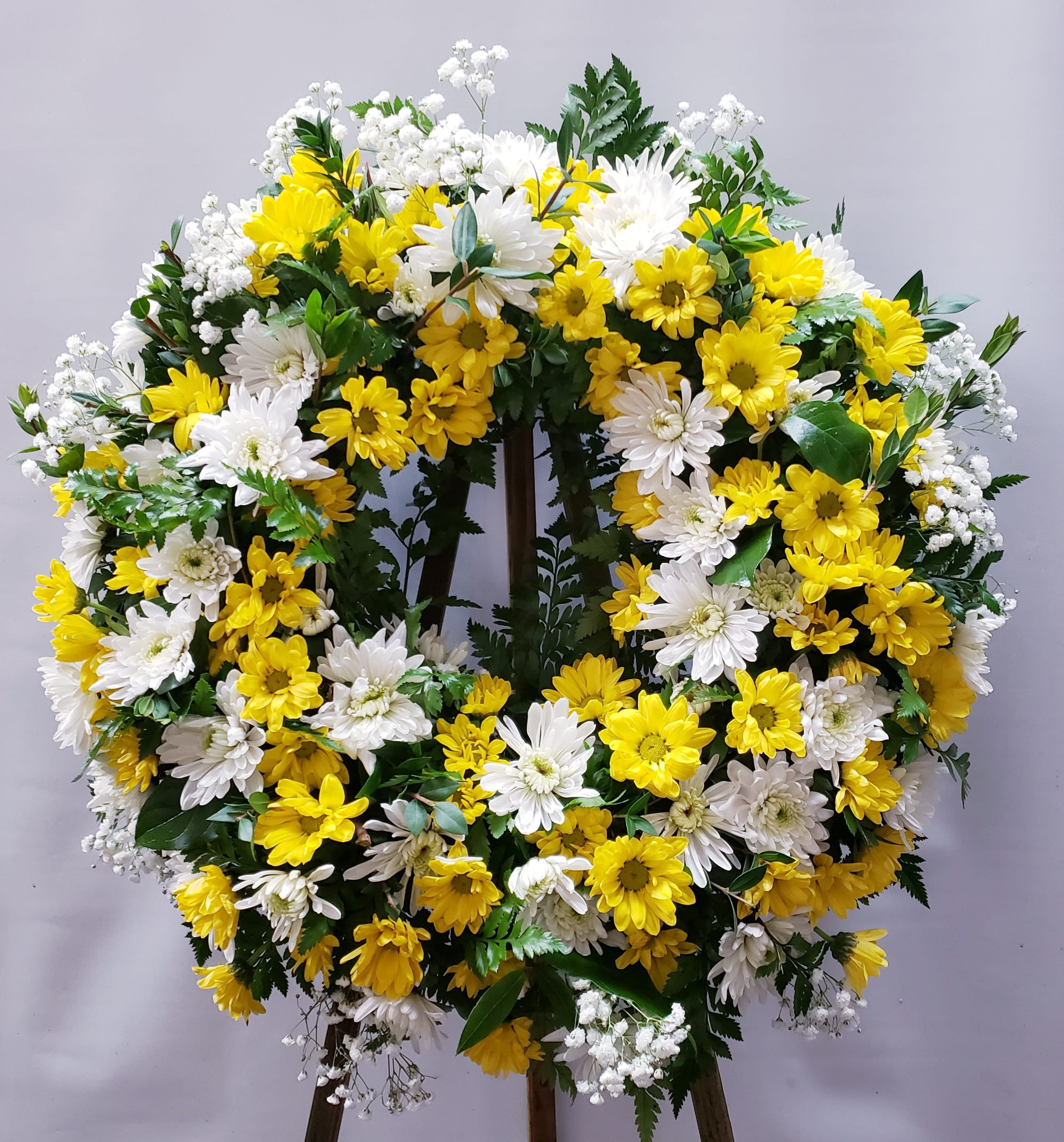 Yellow and white daisy wreath on a standing easel