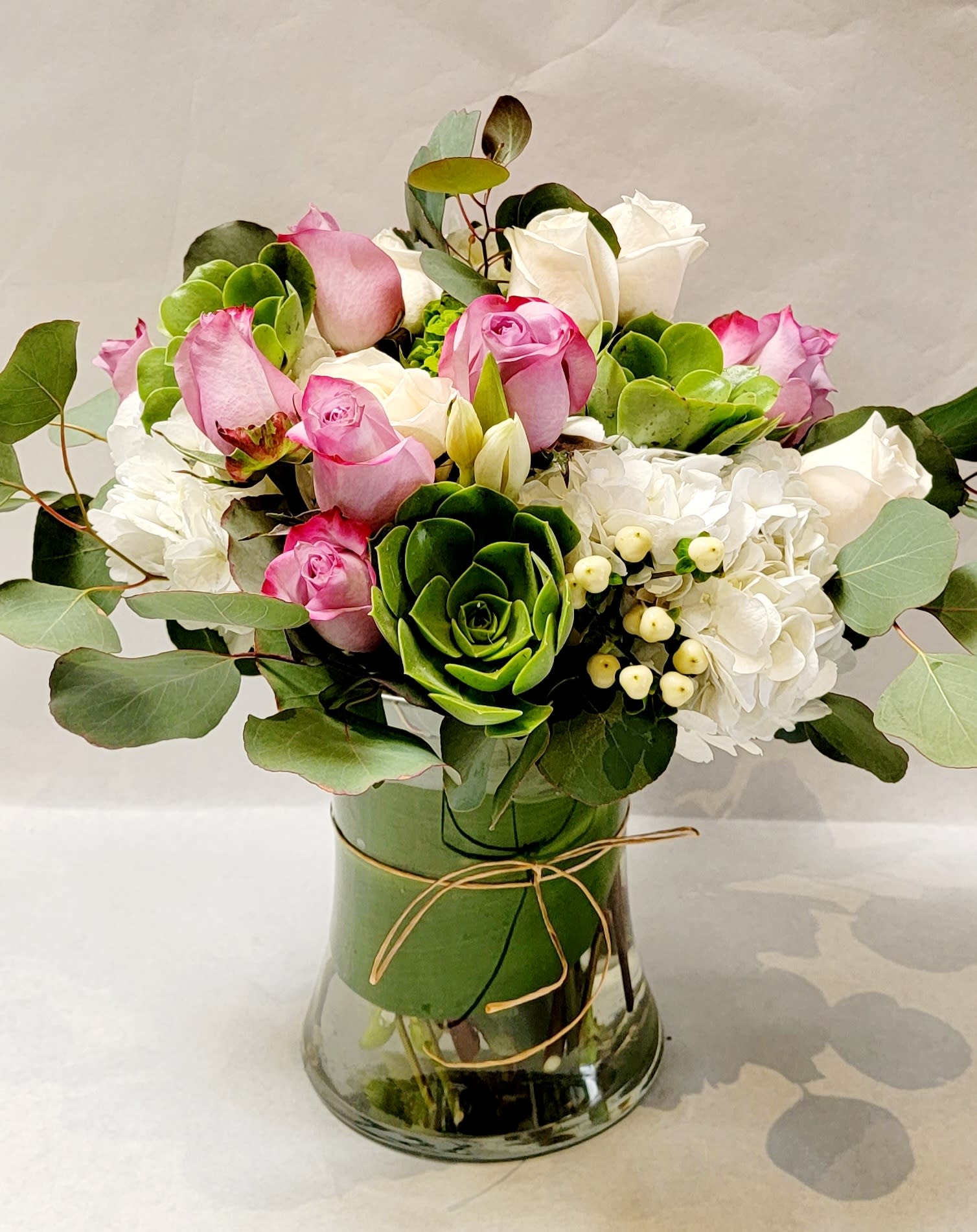Pink and white roses with hydrangeas in a glass vase