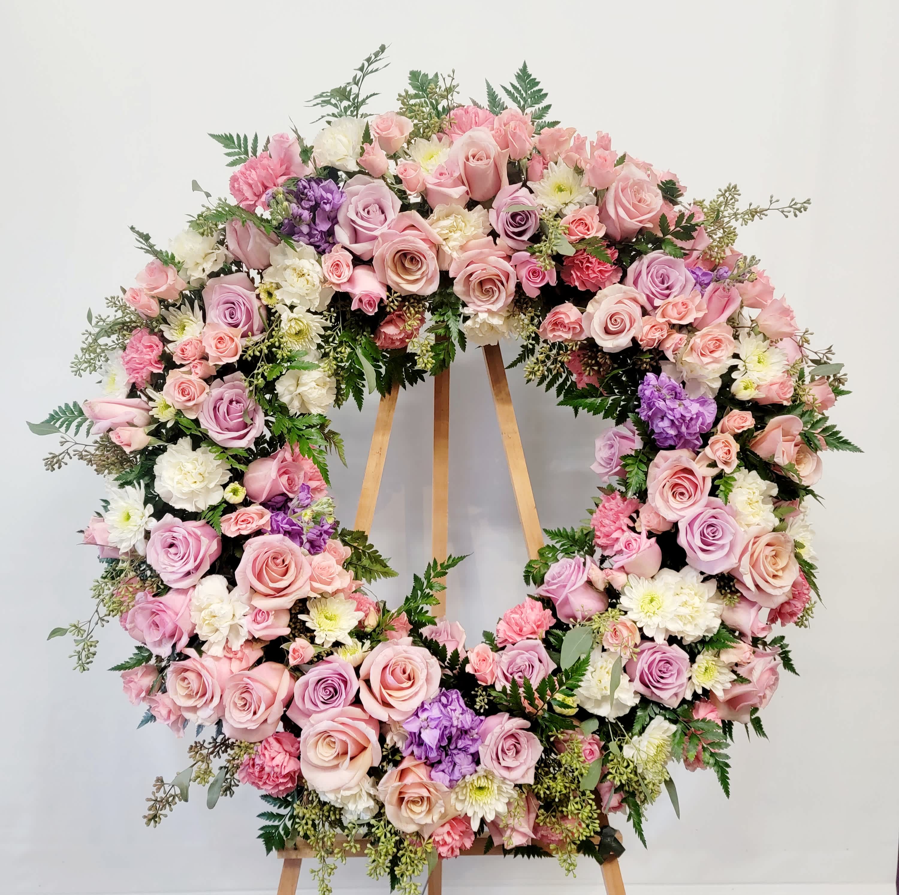 Large pastel floral wreath on a wooden easel
