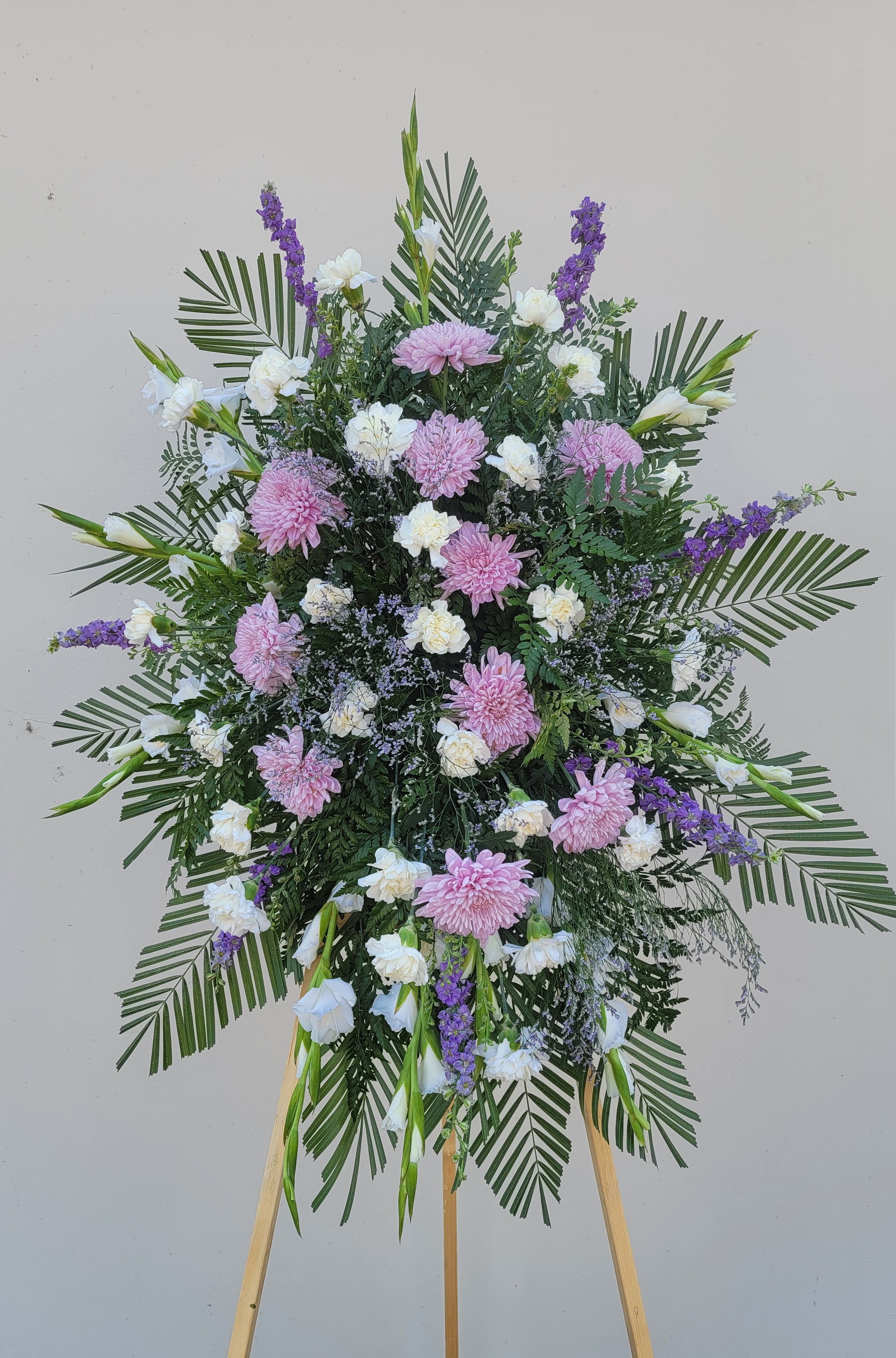 Large standing floral spray with pink and white blooms on an easel