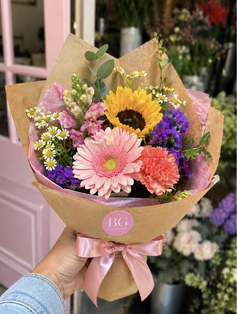 Market Mini, Wrapped Bouquet  - A petite, hand-wrapped bouquet inspired by fresh flower market finds. The Market Mini is designed with a colorful mix of seasonal blooms, soft textures, and airy greenery—wrapped in our signature Bloom Room style.  Perfect for a quick pick-me-up, a thoughtful add-on gift, or just because.  Each bouquet is florist’s choice, meaning no two are exactly alike—but always full, vibrant, and made with love.