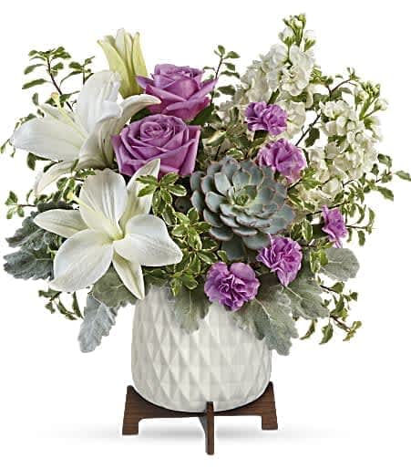 Teleflora's Garden Oasis Bouquet - Straight out of a mid-century design magazine, this chic planter is the perfect vessel for wondrous white lilies, lavender roses and a stunning living succulent plant. 