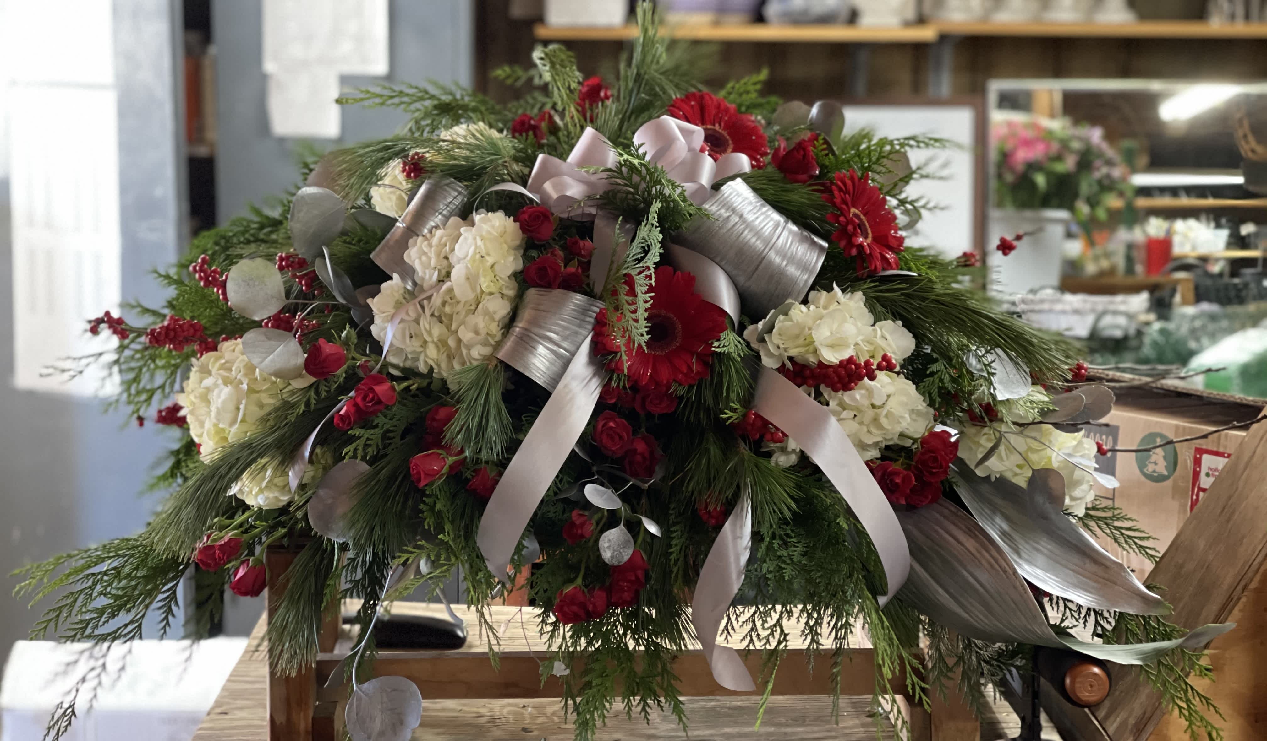 Large red and white floral arrangement with silver ribbon accents