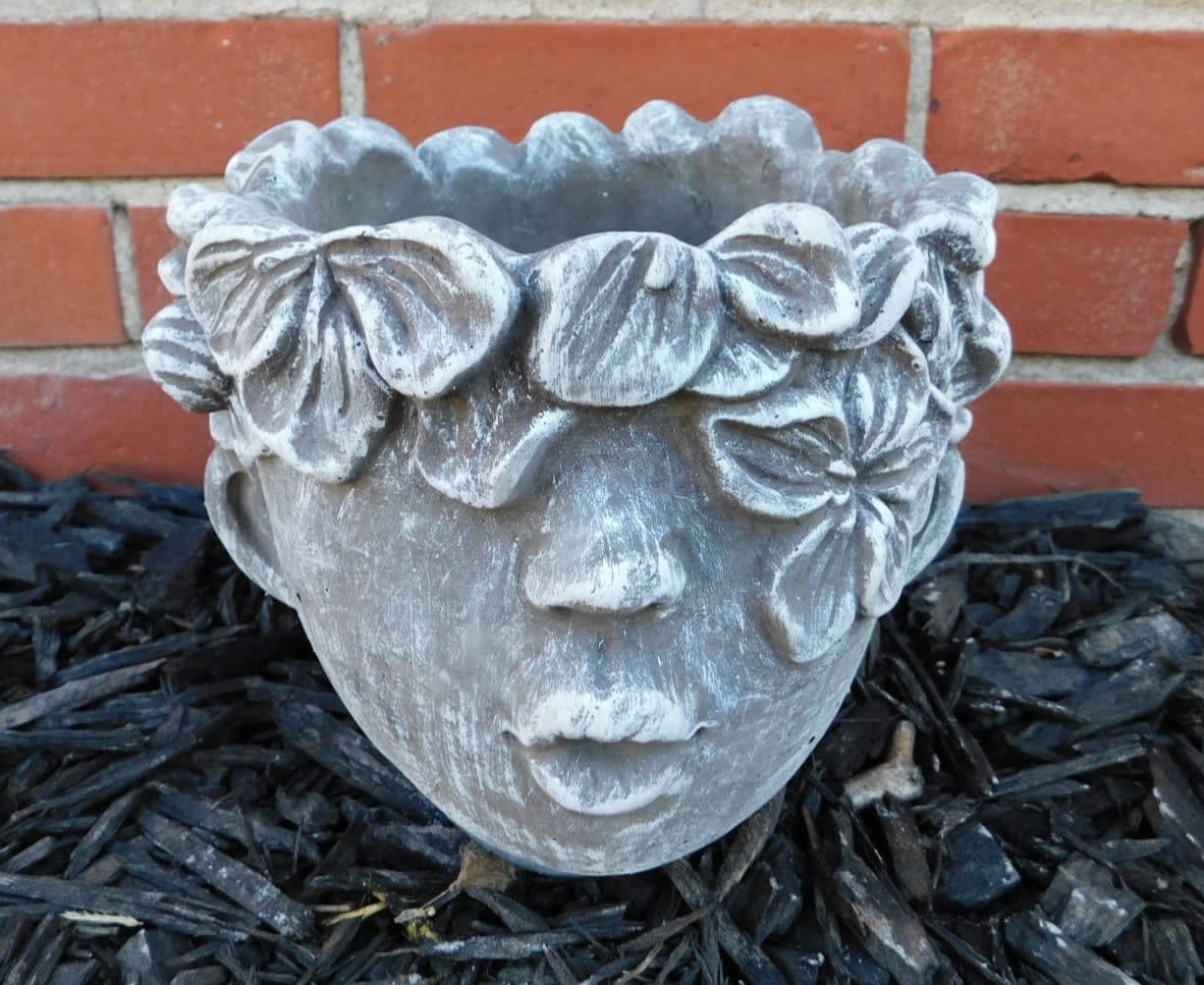 Stone face planter with floral crown detail