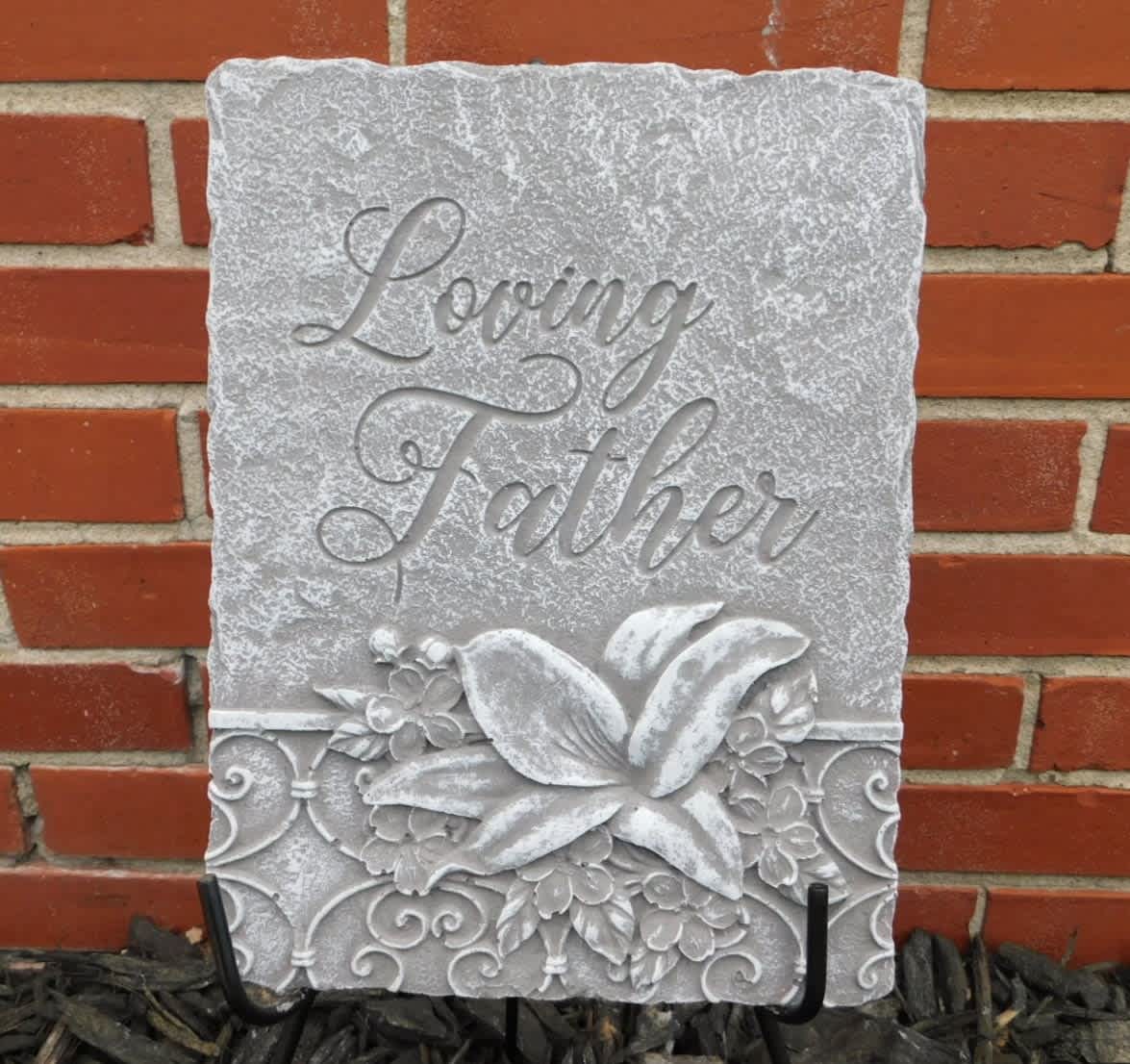 Decorative stone plaque reading "Loving Father" with floral relief