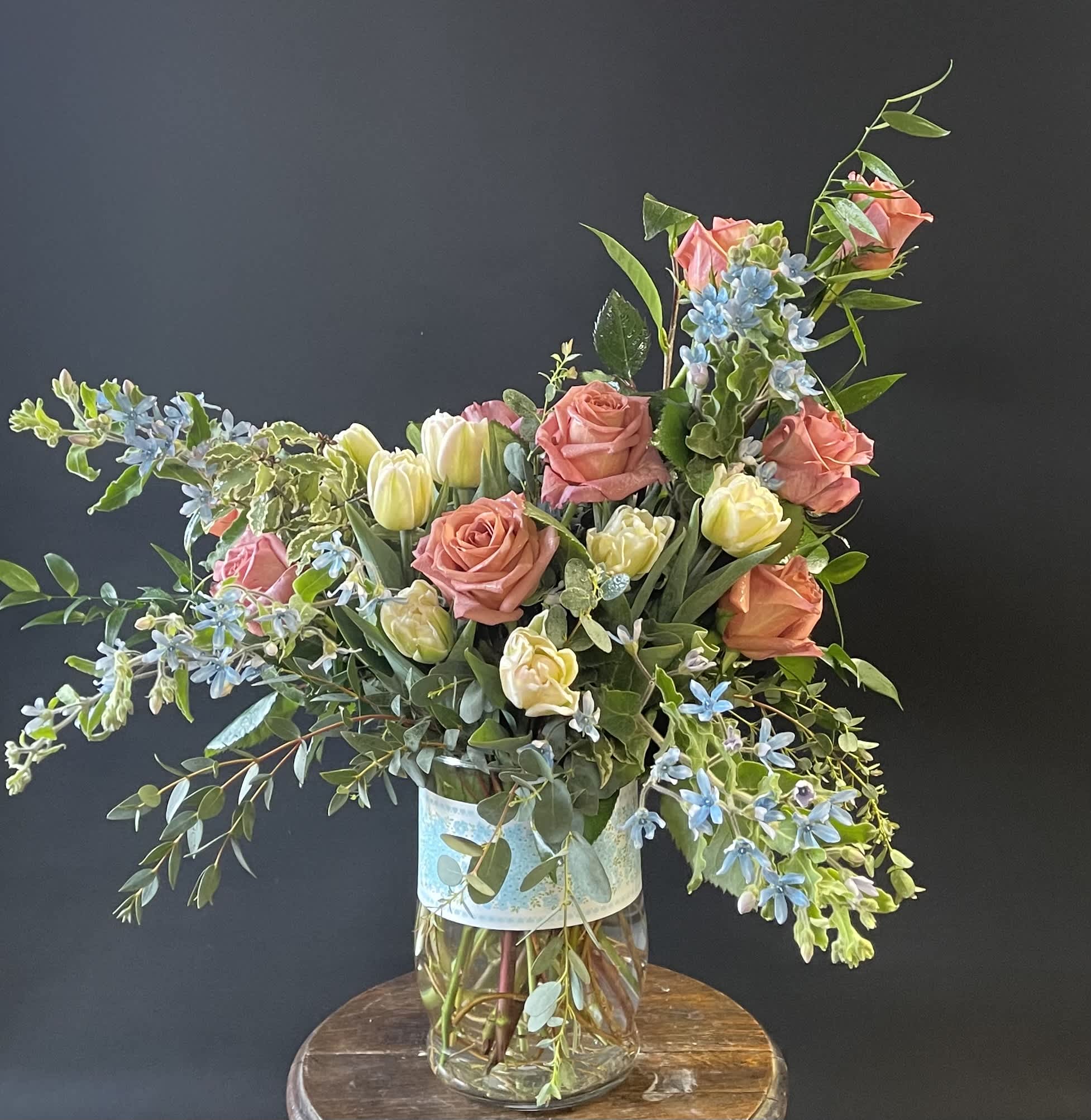 Mixed bouquet of pink roses and pale tulips in a glass vase